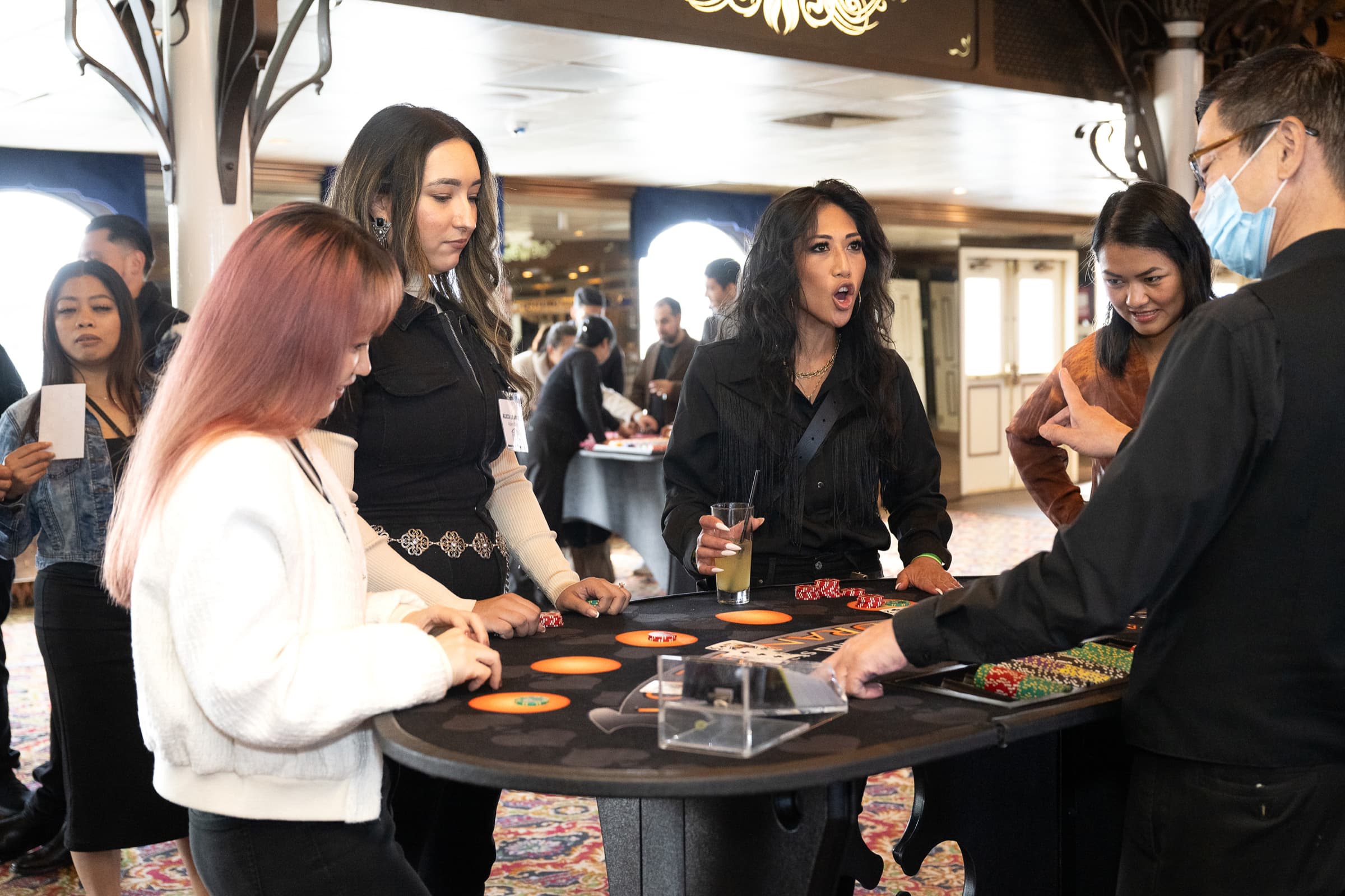 Guests gathered around a gaming table at an evening event