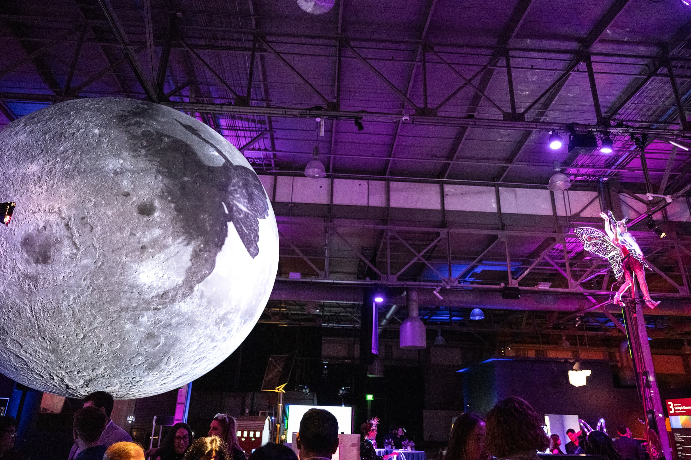 Large illuminated installation photographed inside an event space