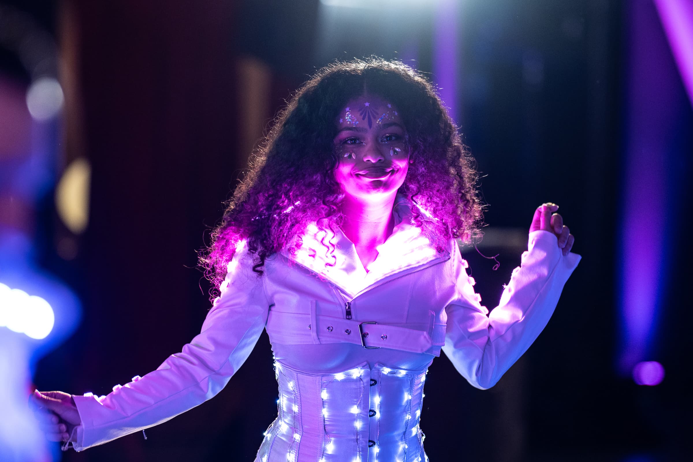 Performer in an illuminated costume during a late-night event