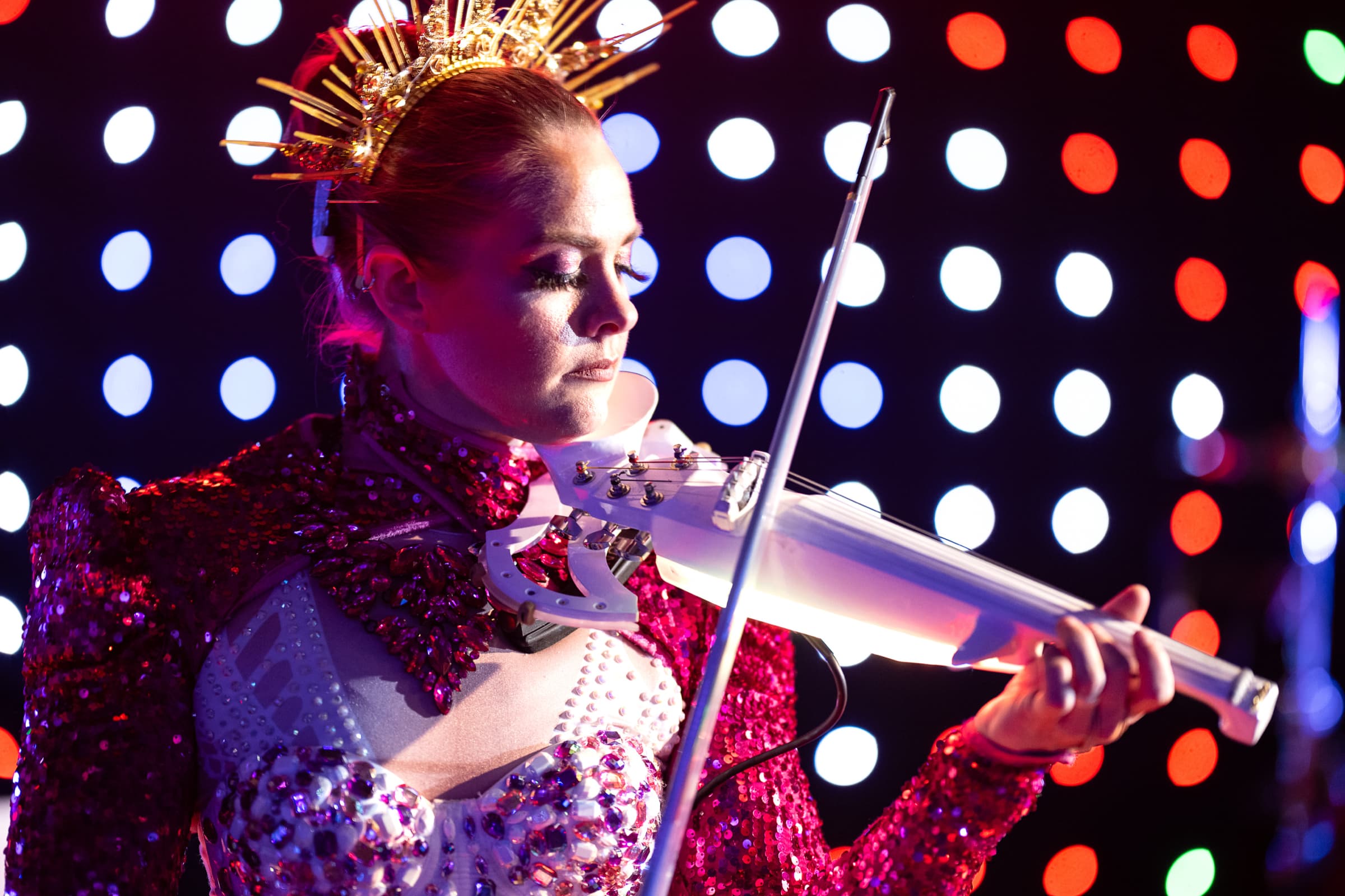 Violinist performing against an illuminated backdrop