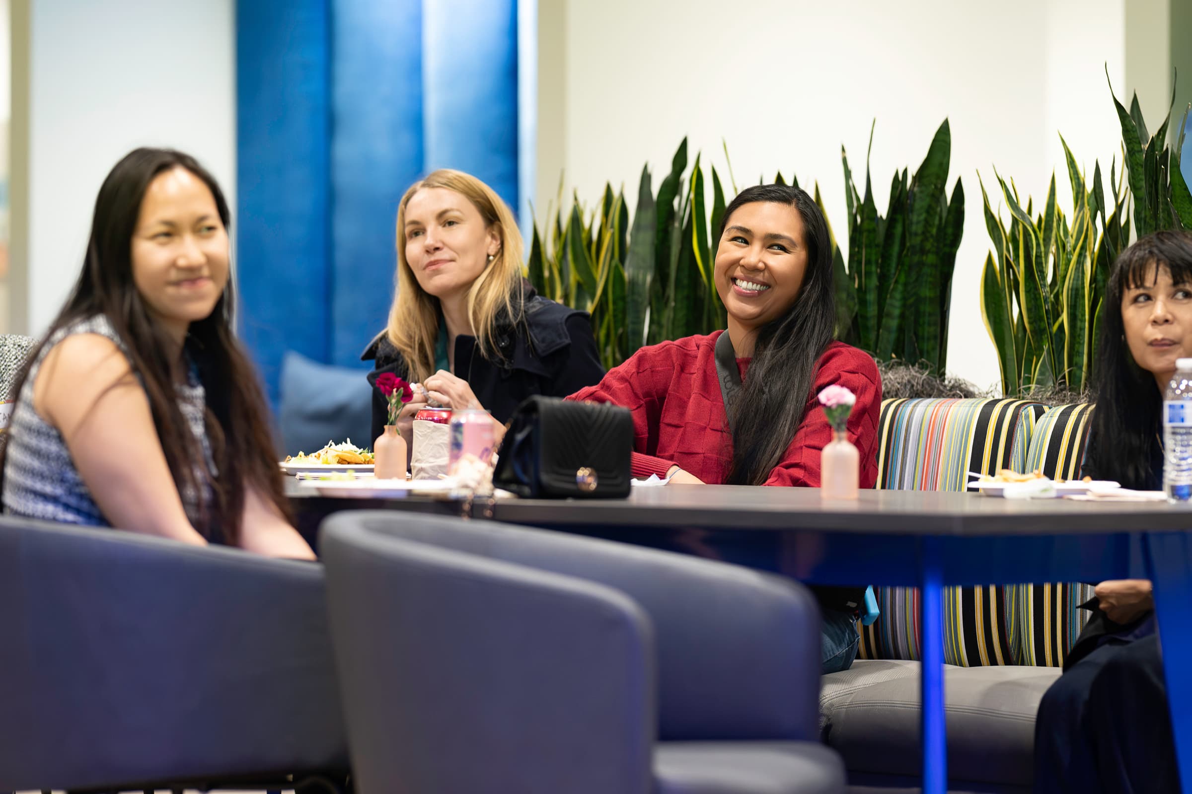 Attendees in conversation in a lounge area between sessions