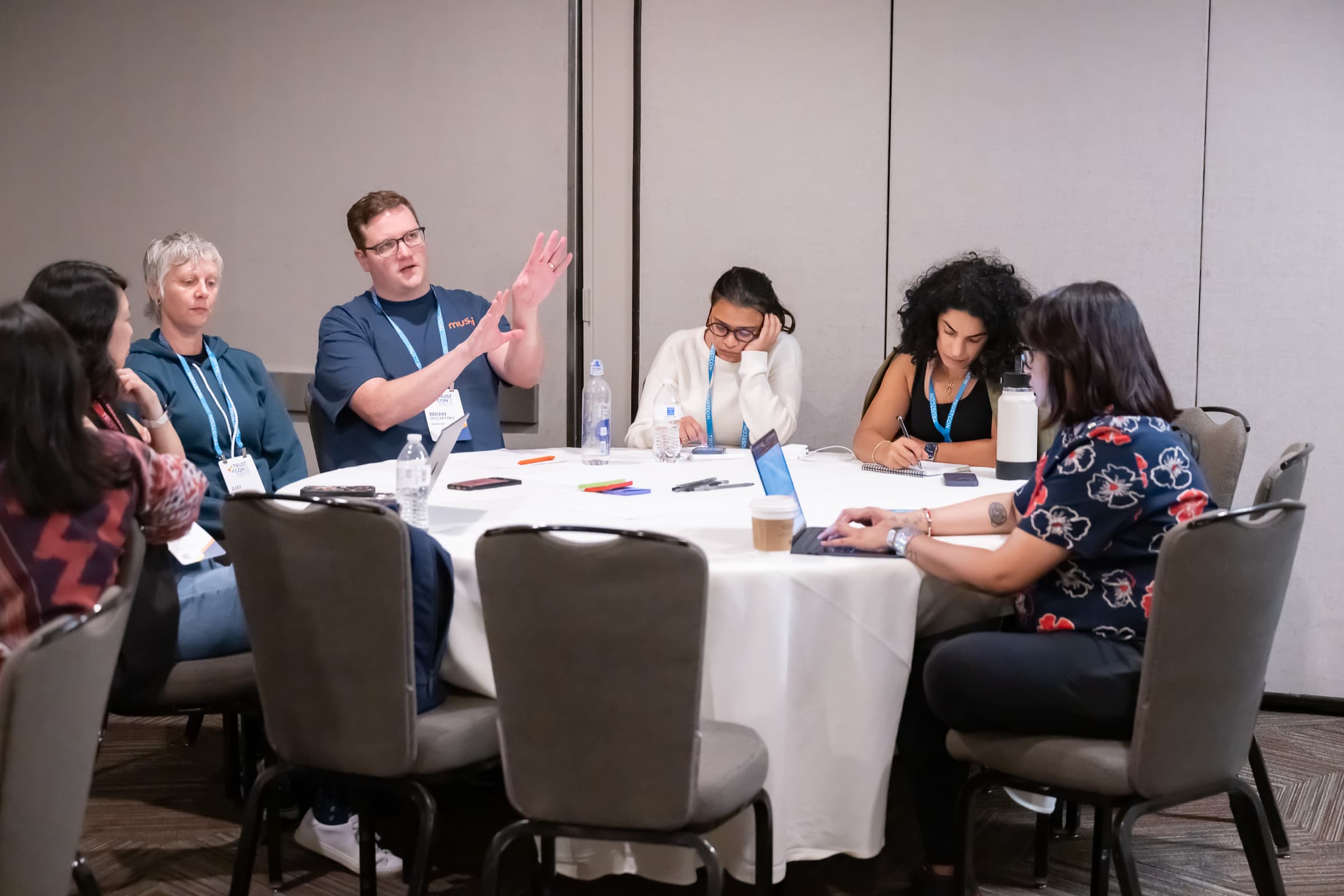 Attendee raising a hand at a roundtable during a working session