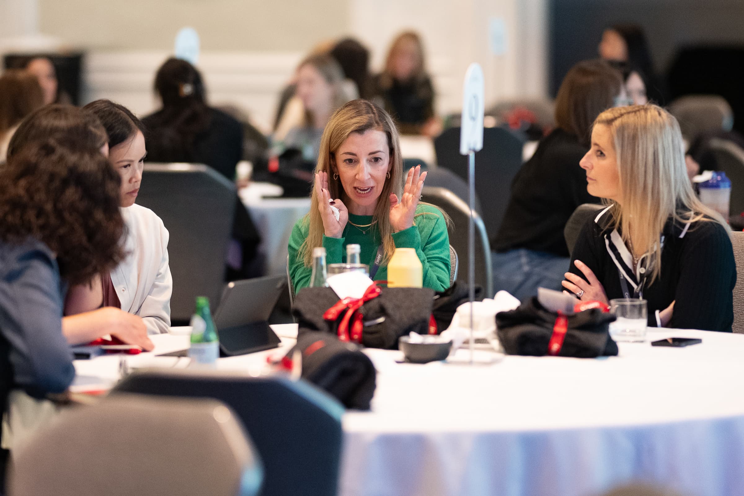 Group of attendees listening around a table during a breakout