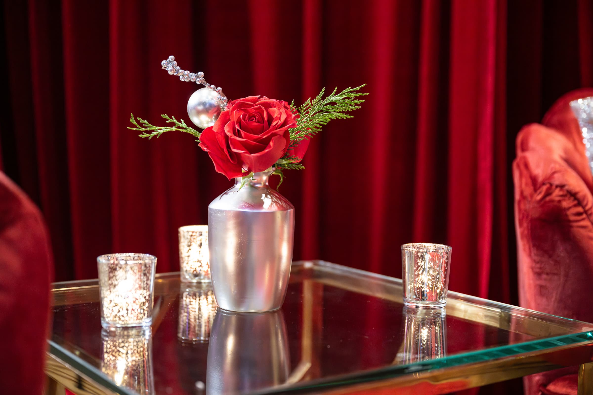 Rose centrepiece and candlelight photographed close on a dinner table