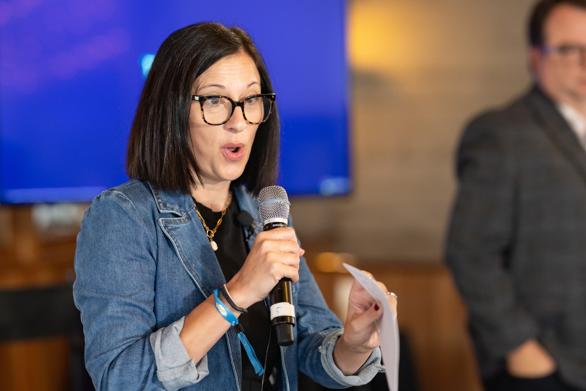 Guest asking a question with a handheld microphone during a hosted breakfast