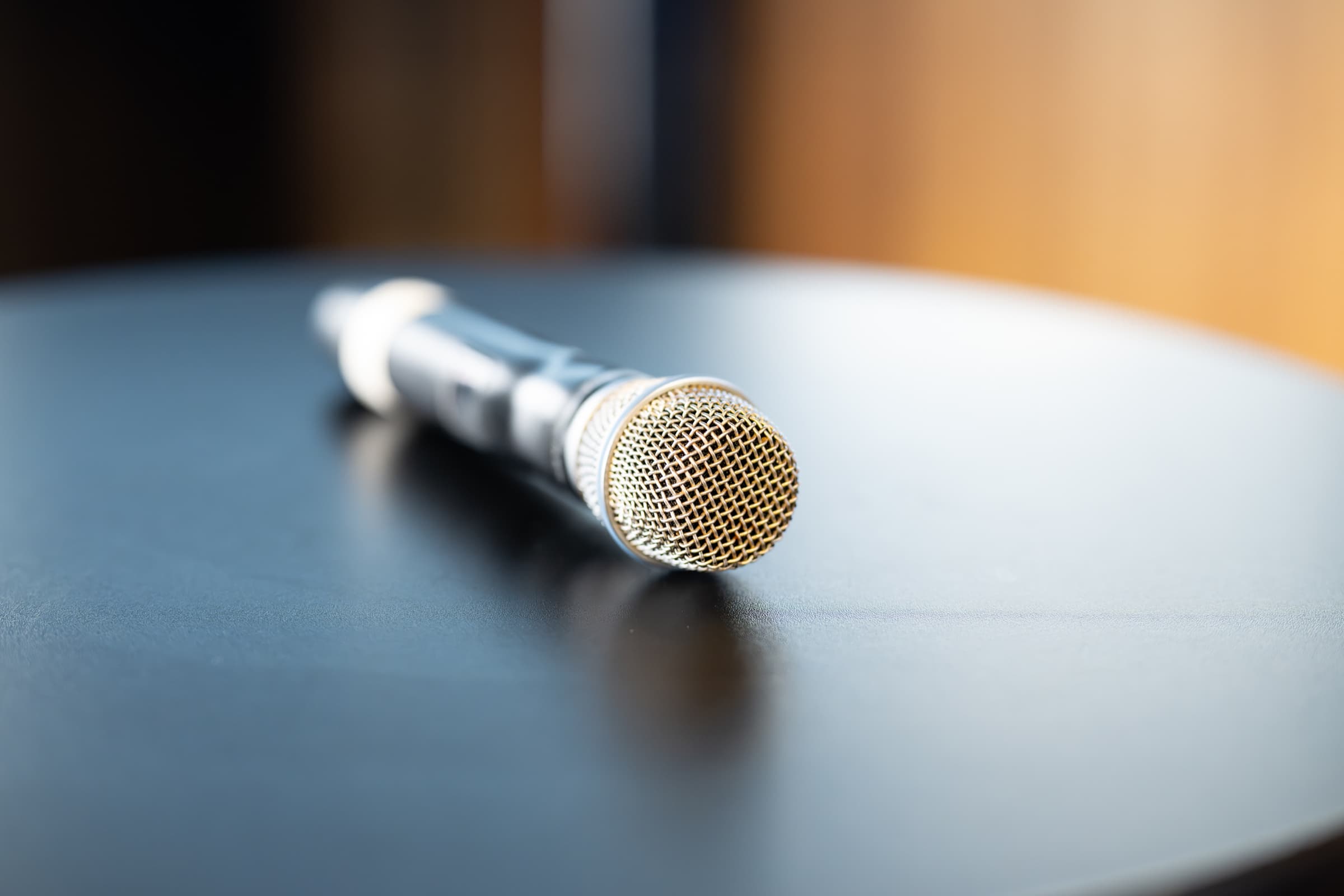 Handheld microphone resting on a table before remarks begin