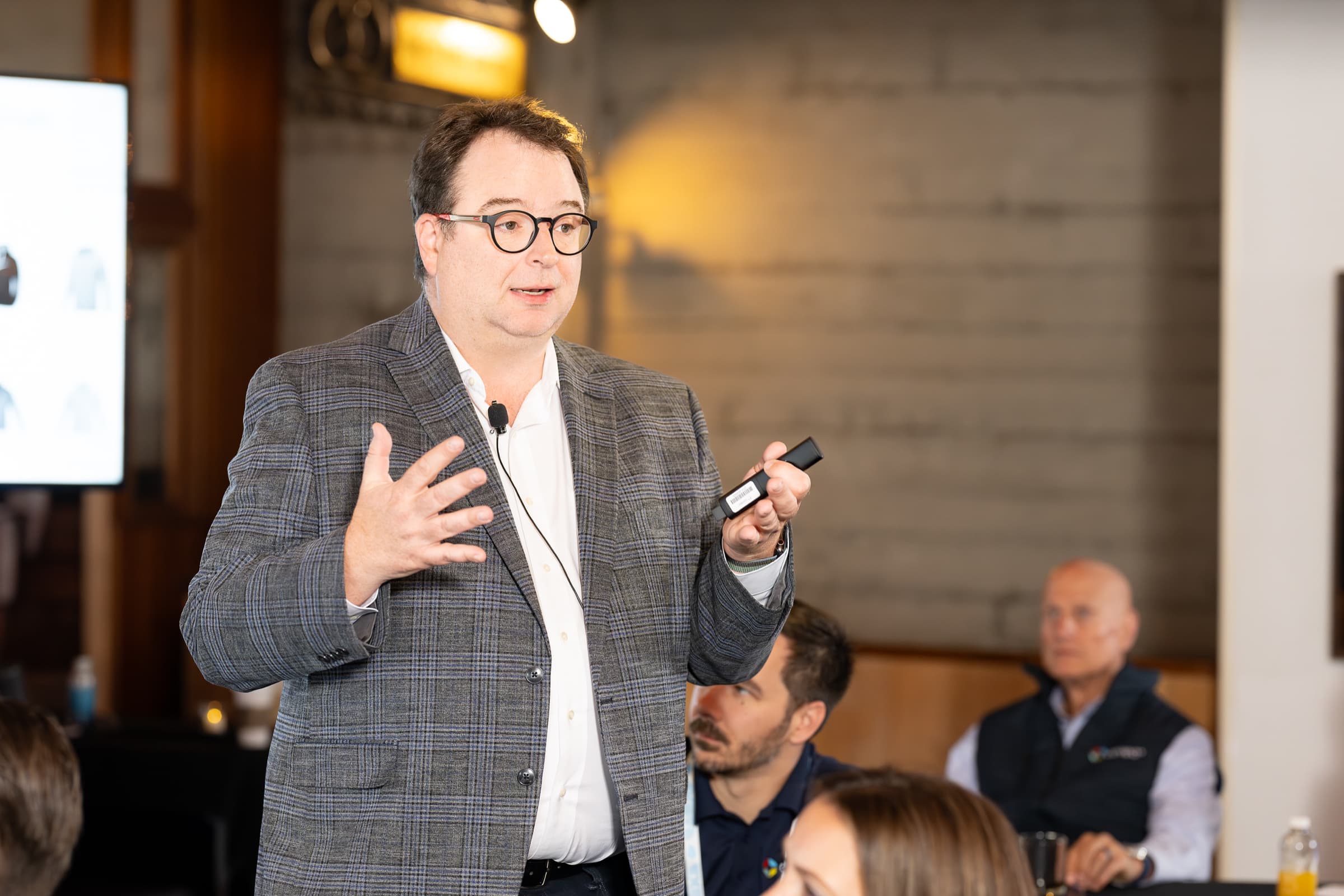 Host giving brief remarks during a hosted breakfast in window light