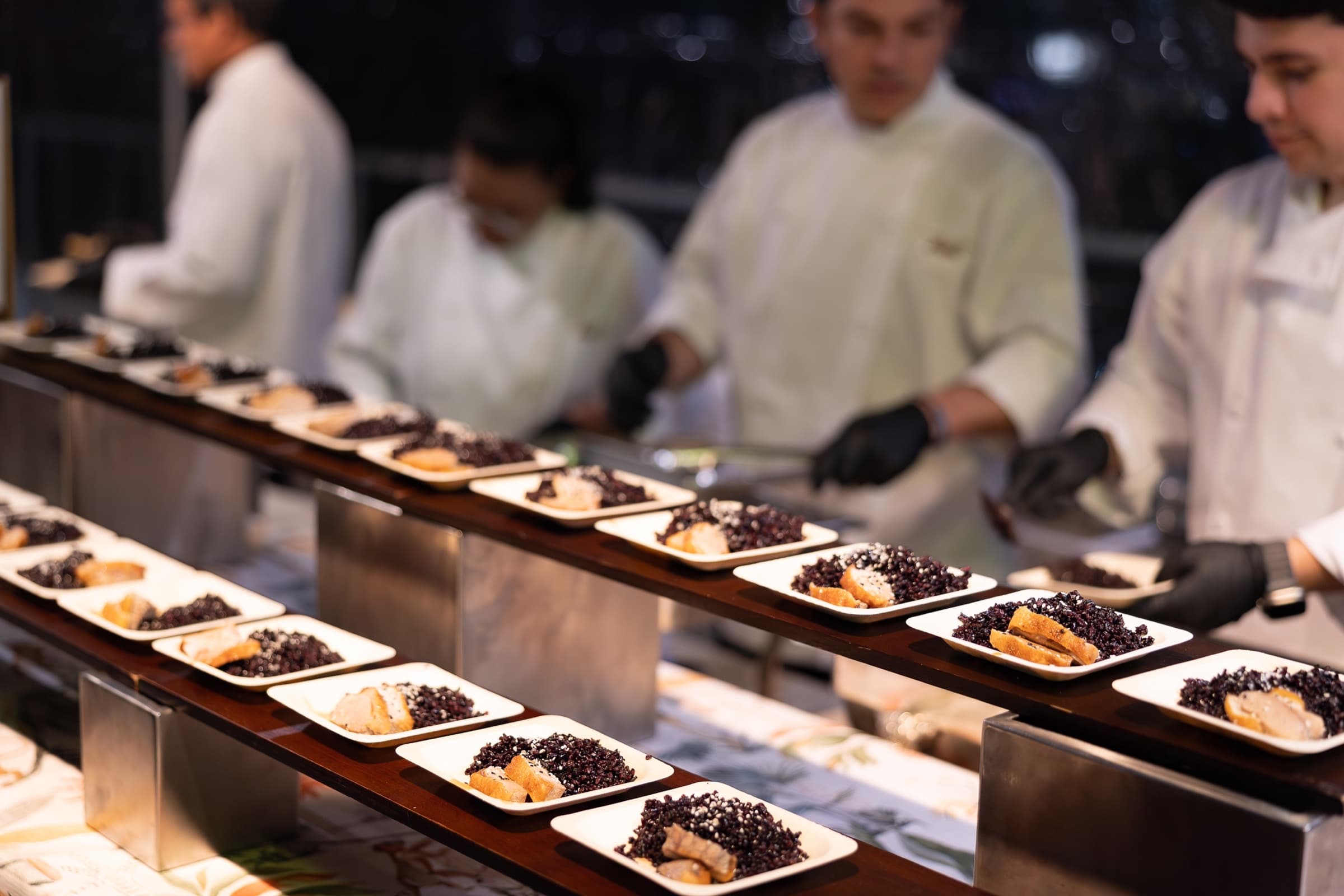 Catering team plating fresh appetizers at a reception station
