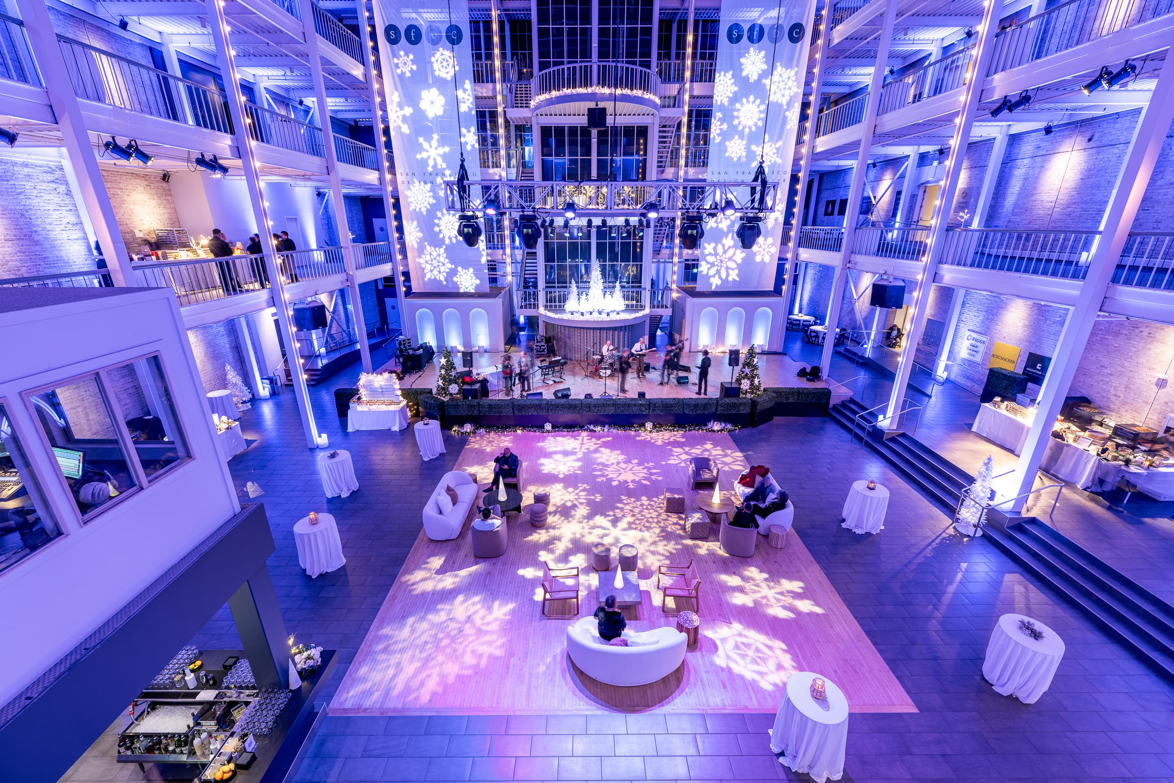Ballroom set with tables and blue uplighting before a holiday party begins