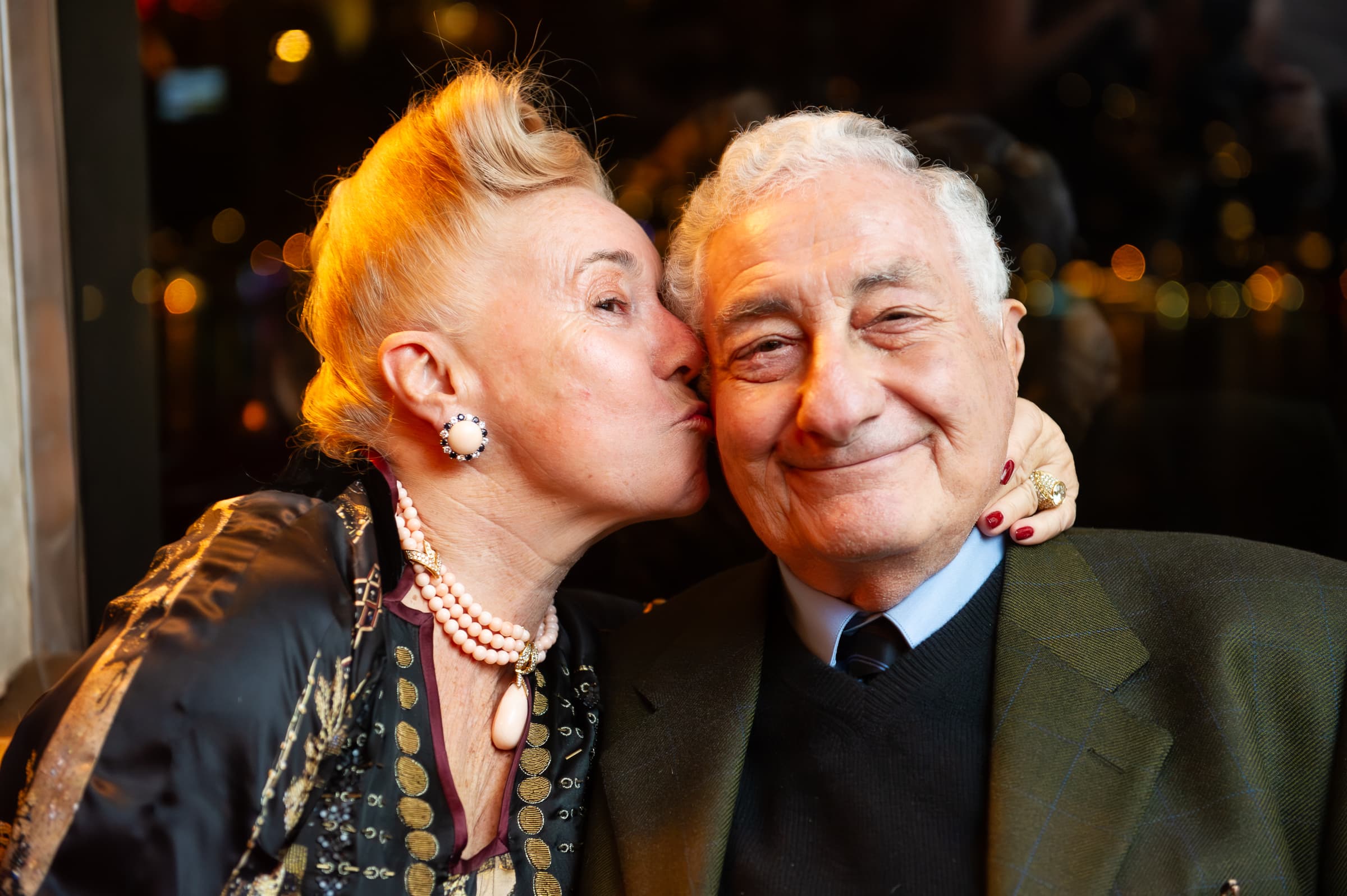 Two guests sharing an affectionate moment at a company holiday party