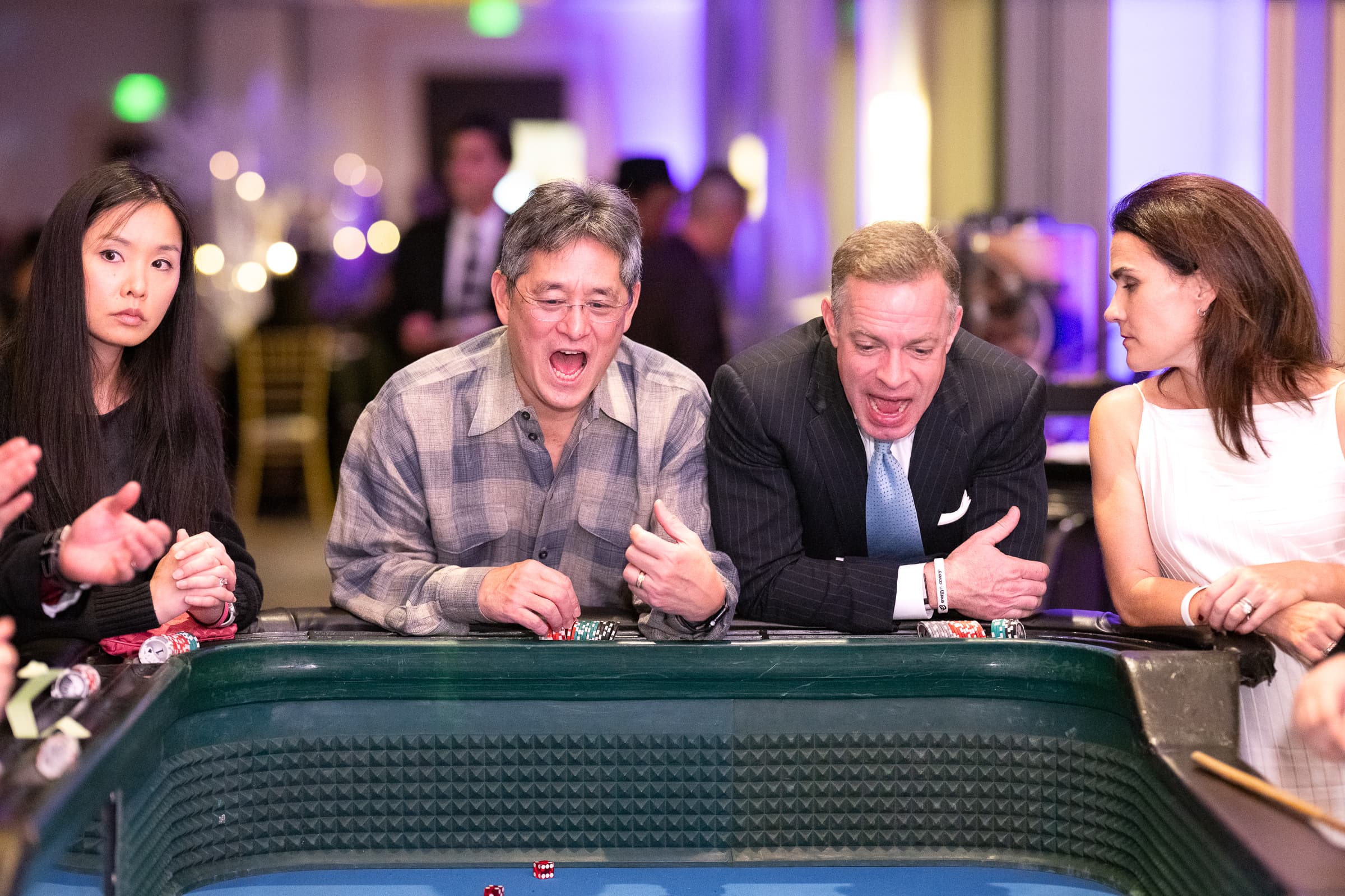 Guests reacting to a win at a gaming table during a company holiday party
