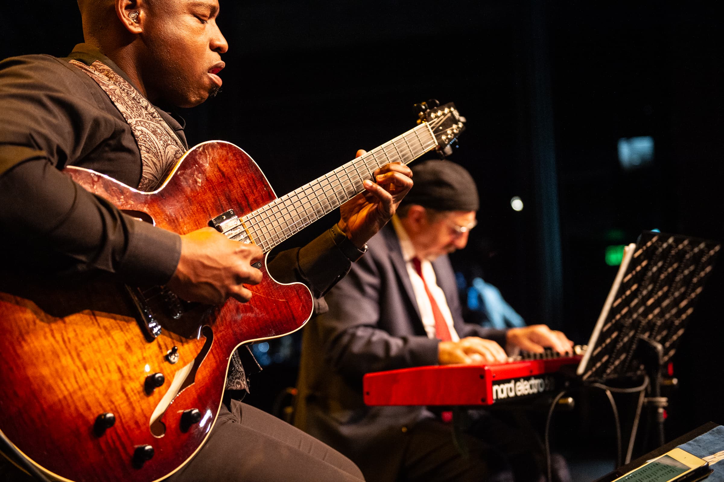 Guitarist performing with an ensemble at a company holiday party