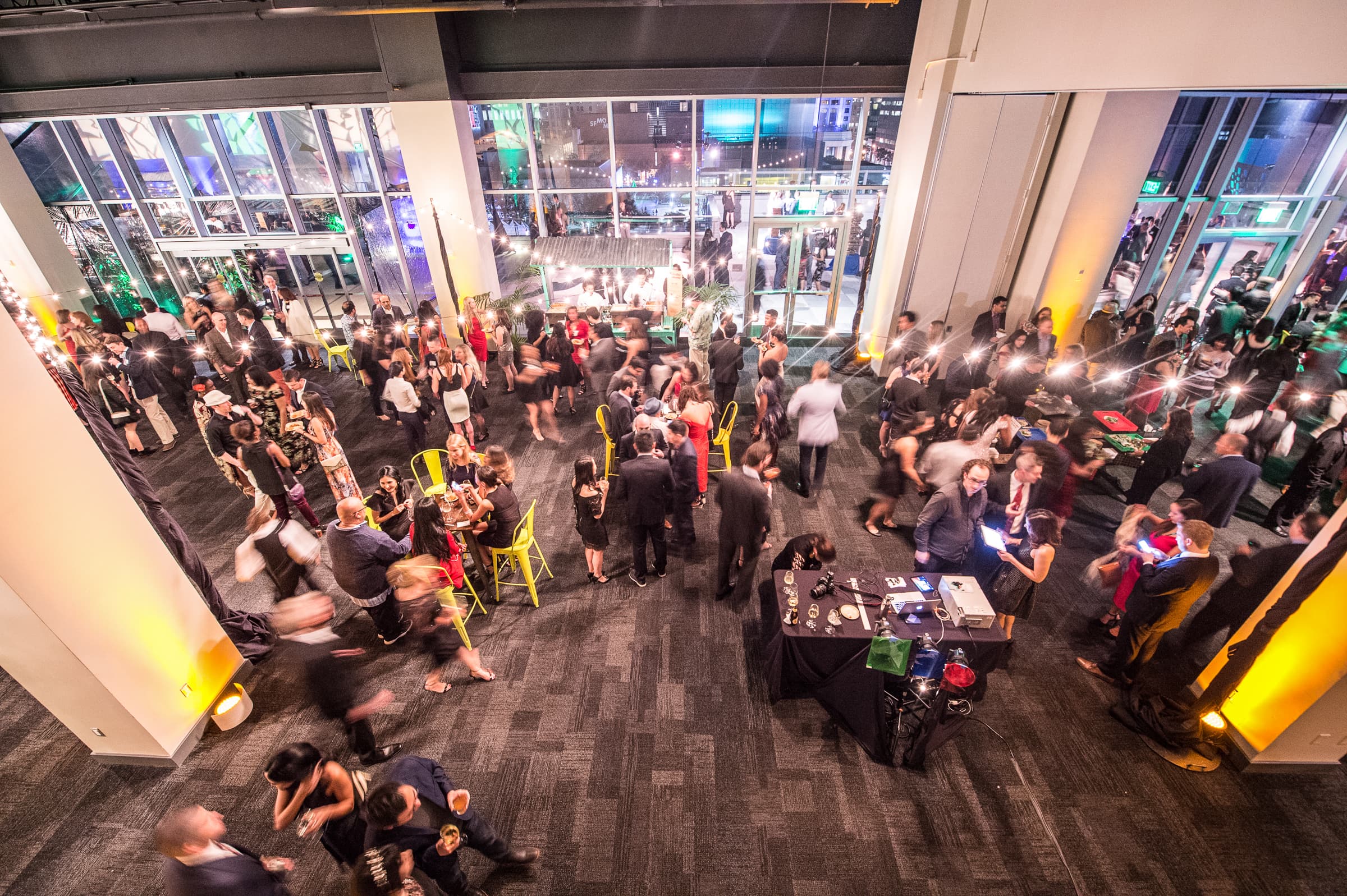 Wide view of a full holiday party room with guests at tables