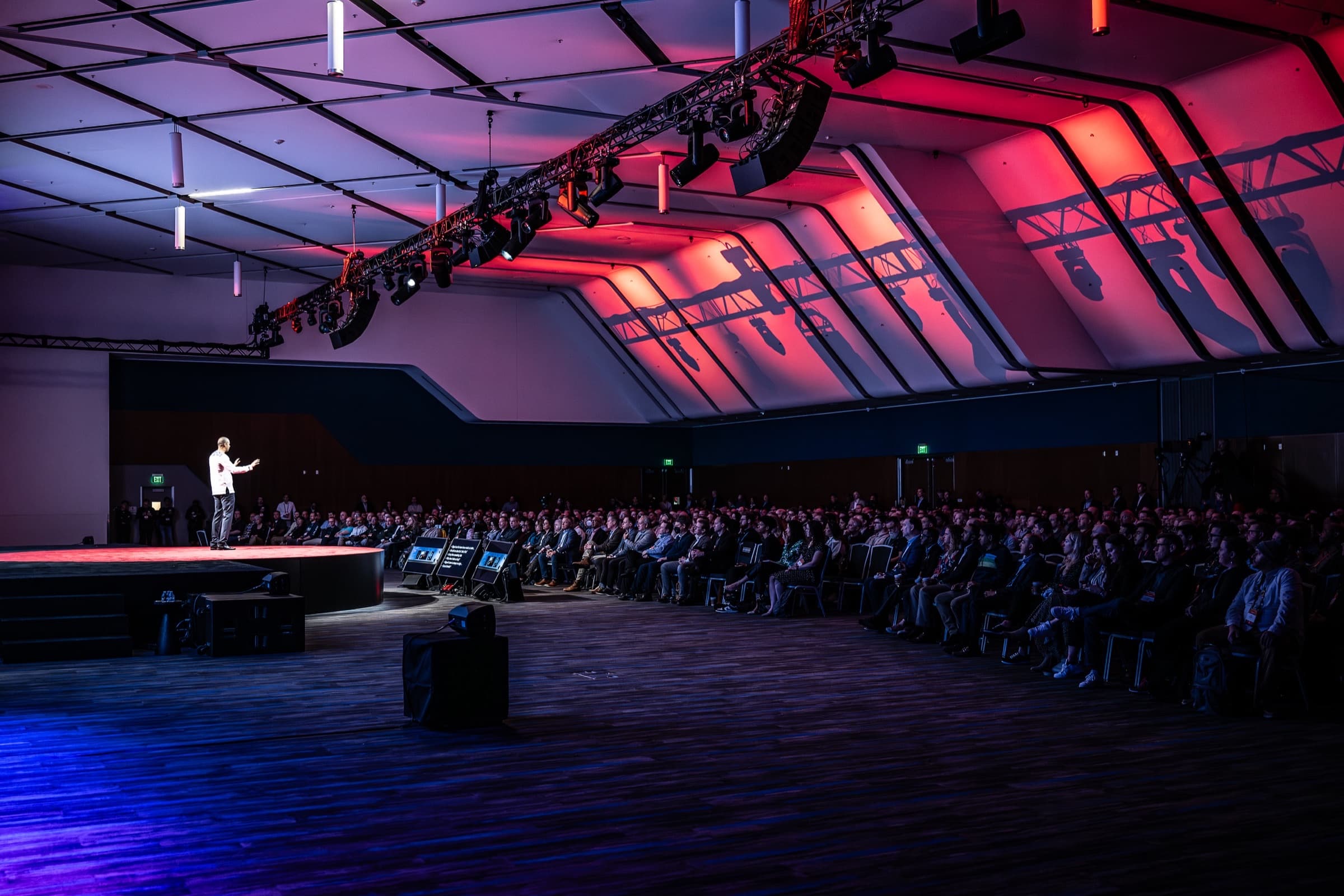 Wide view of a general session hall showing the lighting truss and the scale of the room