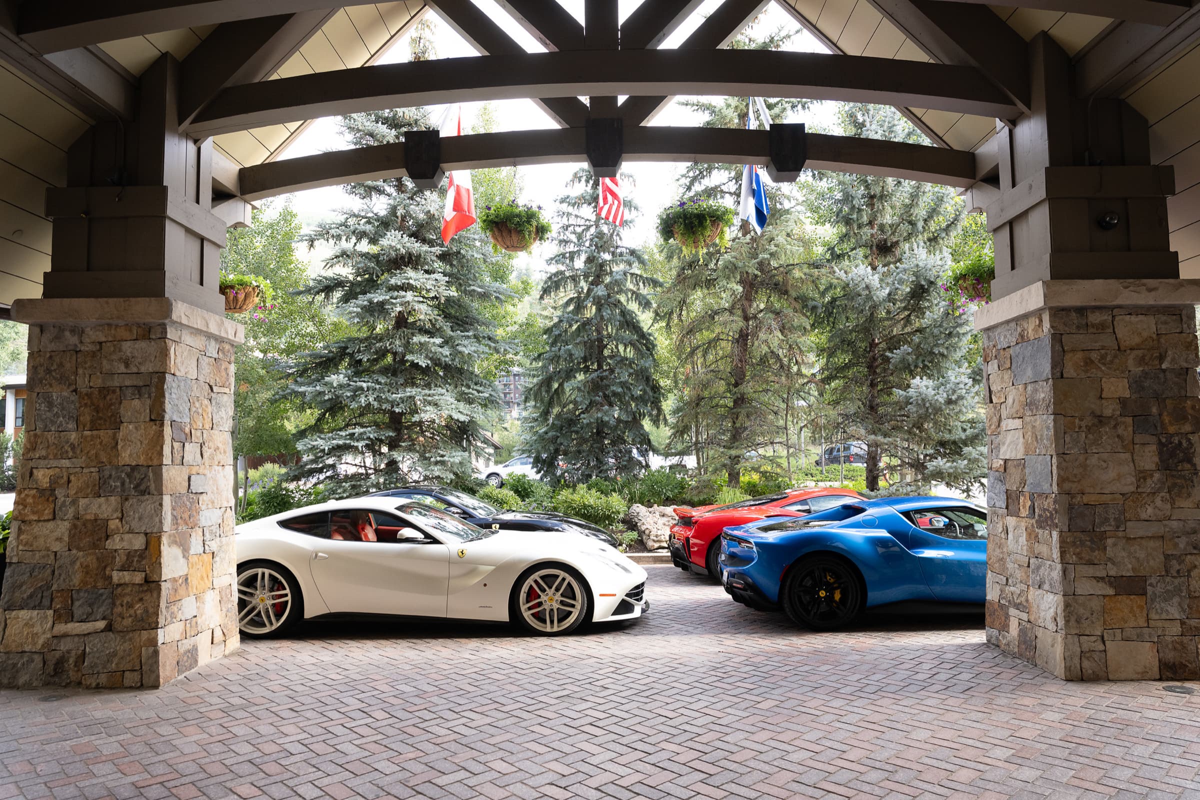 Sports cars gathered at a mountain resort entrance