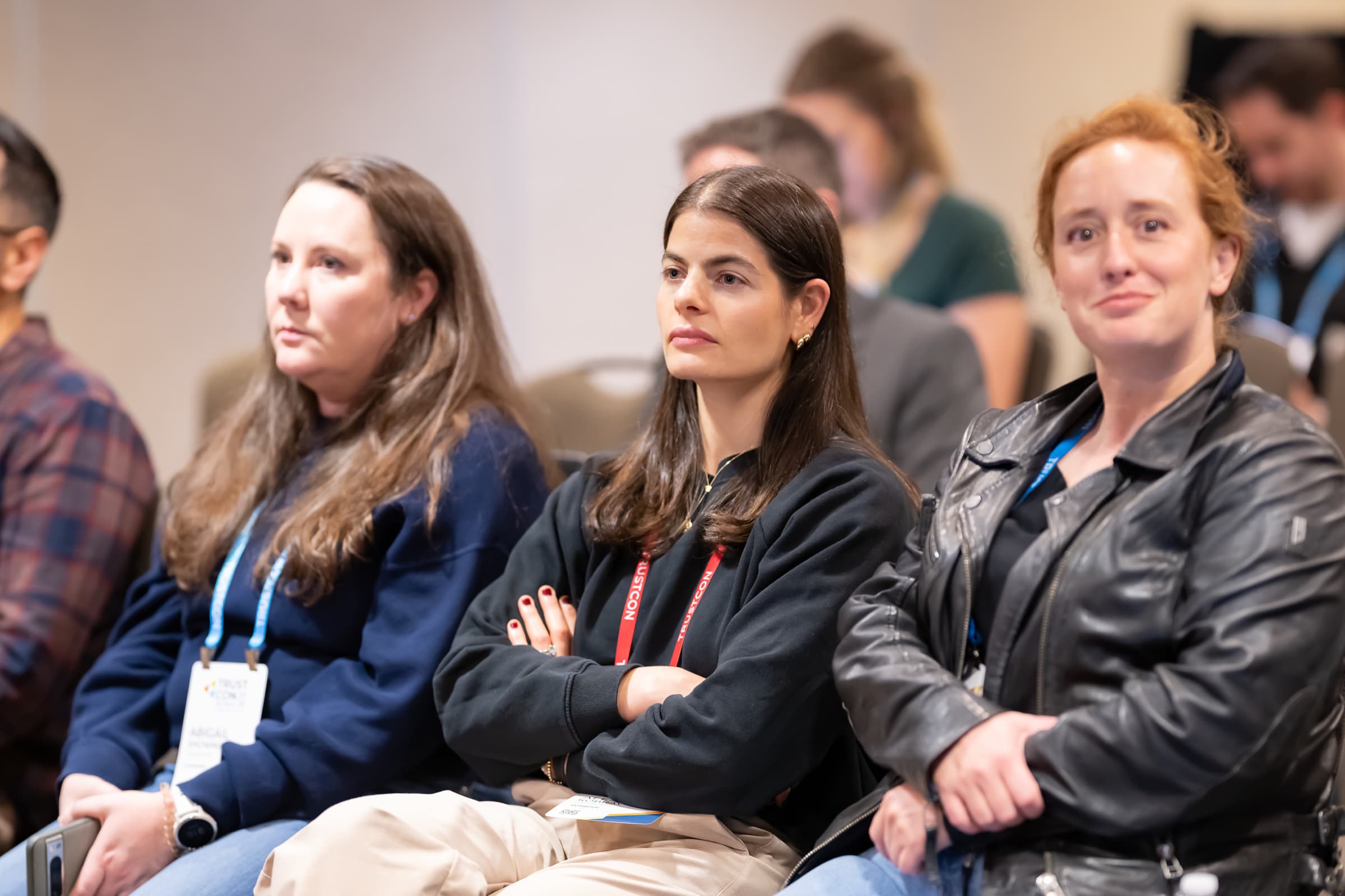 Attendees seated in a row listening during a conference panel