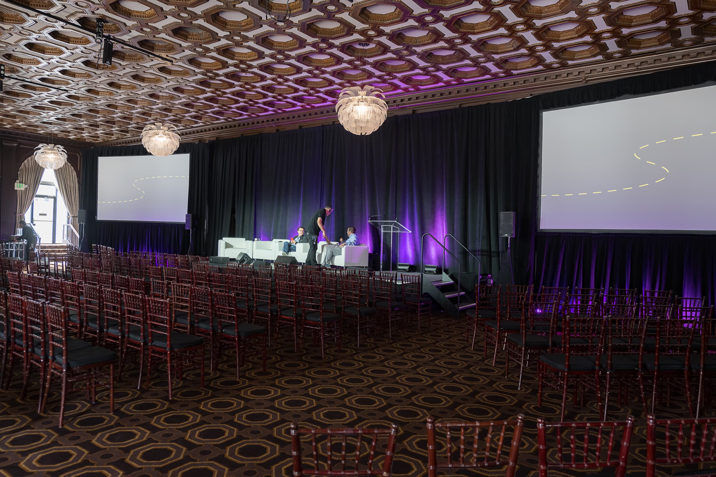 Empty ballroom set with a lit stage before a panel session opens