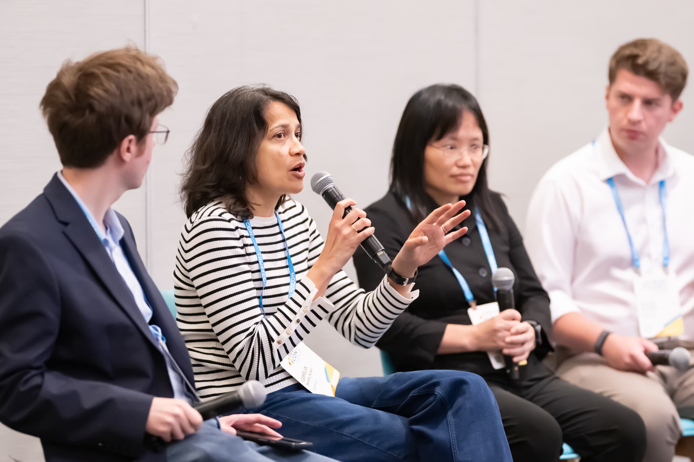 Panelist speaking into a handheld microphone during a session