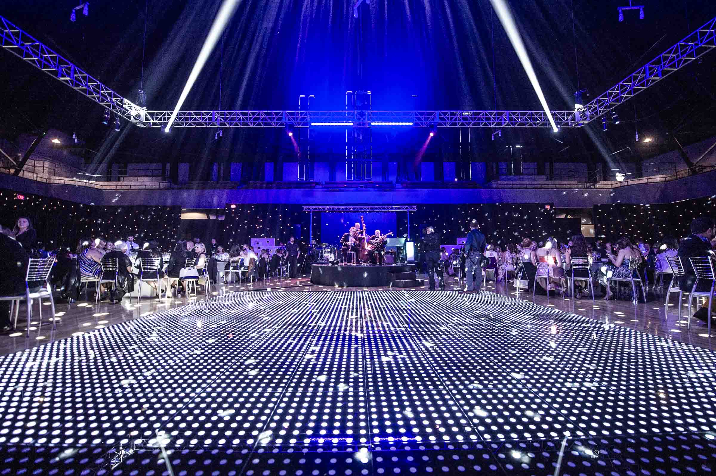 Illuminated LED dance floor at corporate gala with live band performance