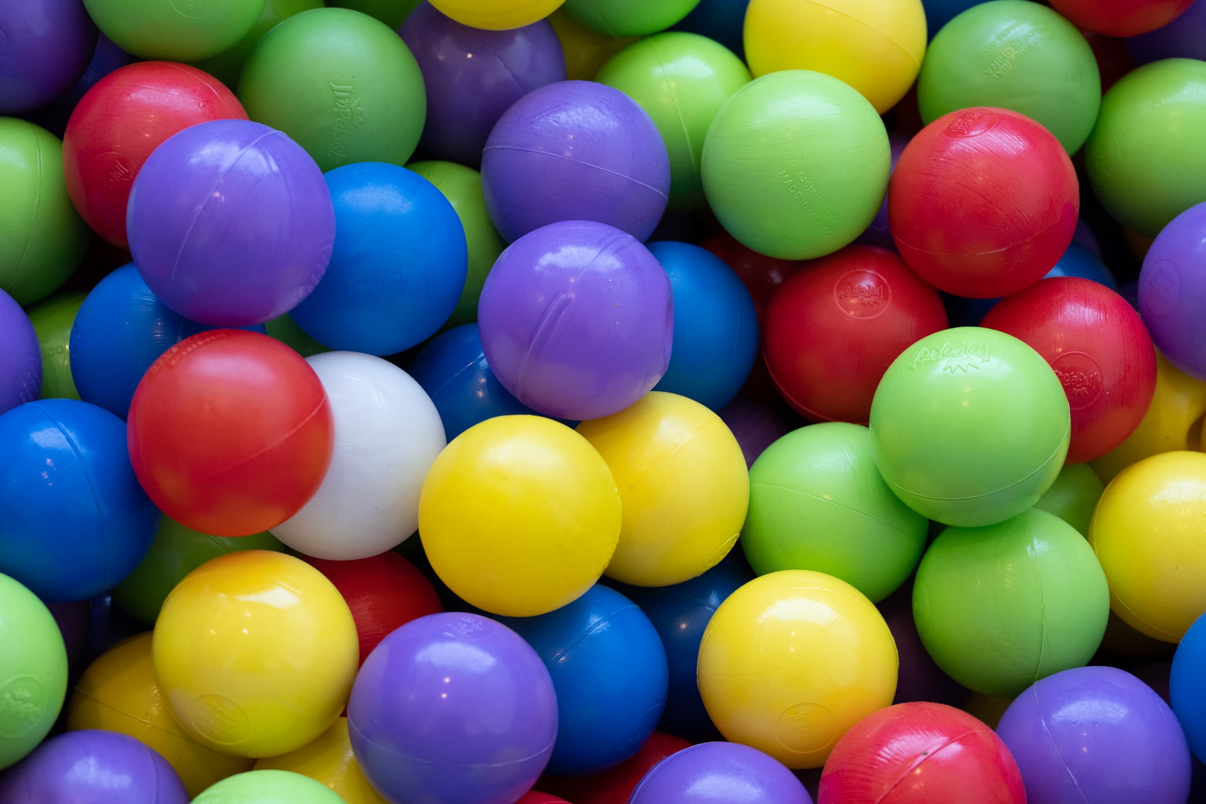 Close view of a ball pit installation filled with primary-coloured spheres
