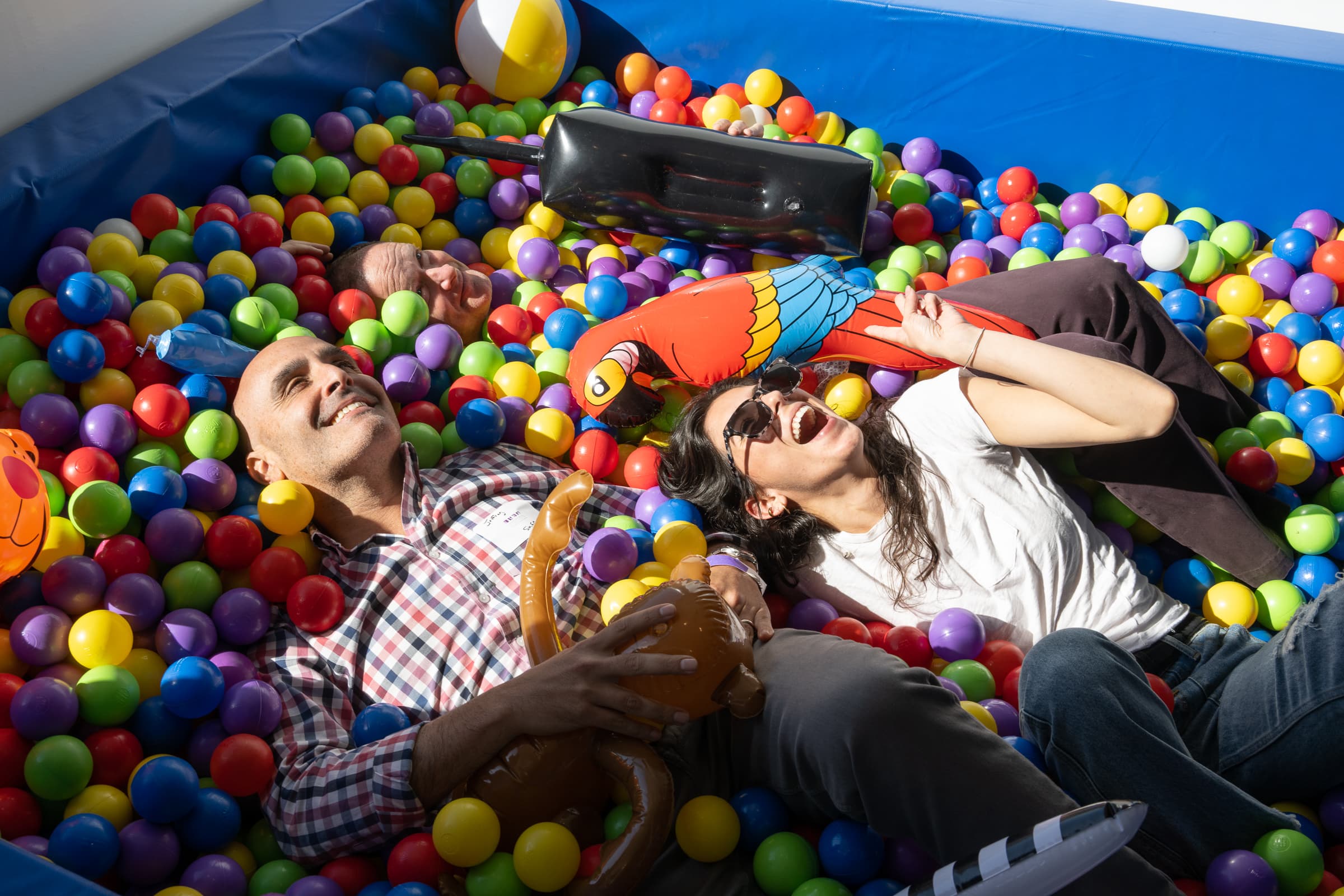 Guests lying in a ball-pit installation surrounded by coloured spheres