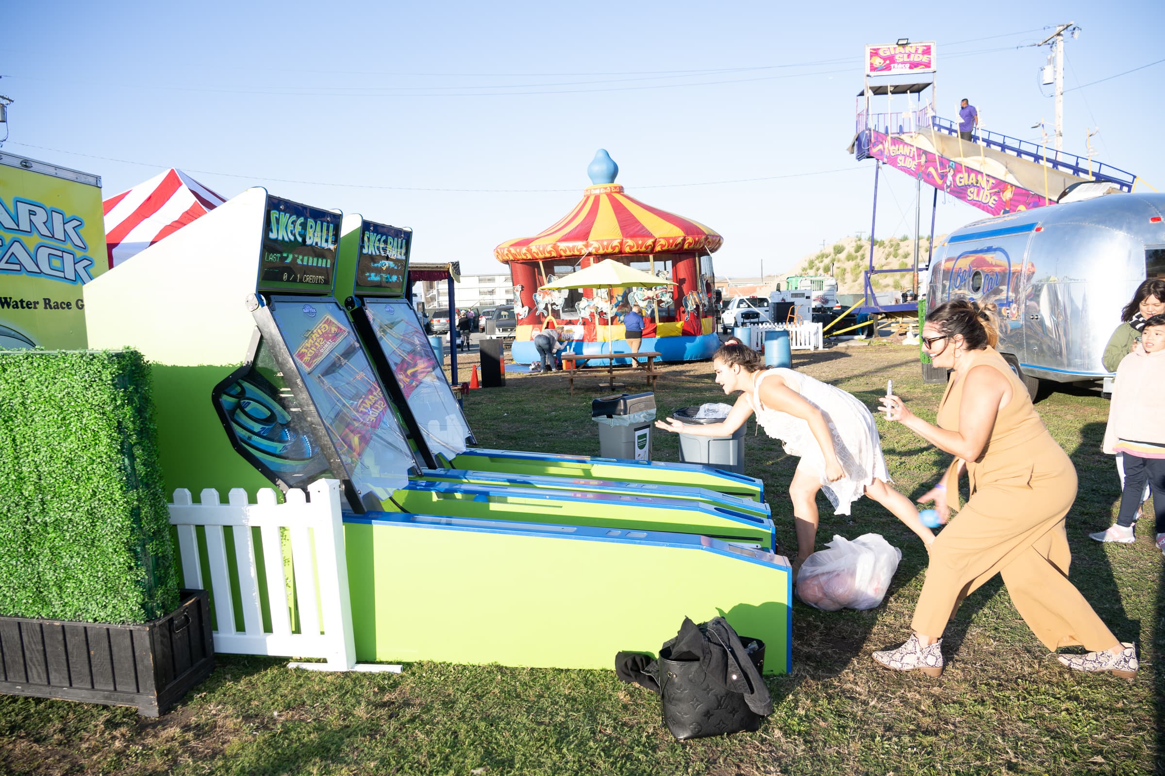 Outdoor lawn-games activation with carnival rides behind