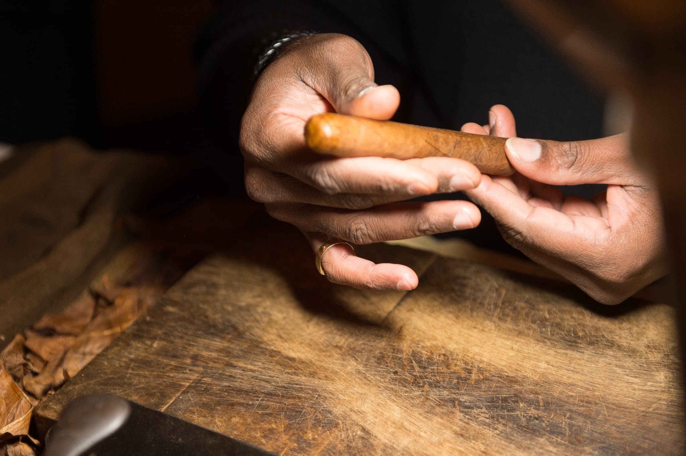 Hands rolling a cigar at a live rolling station