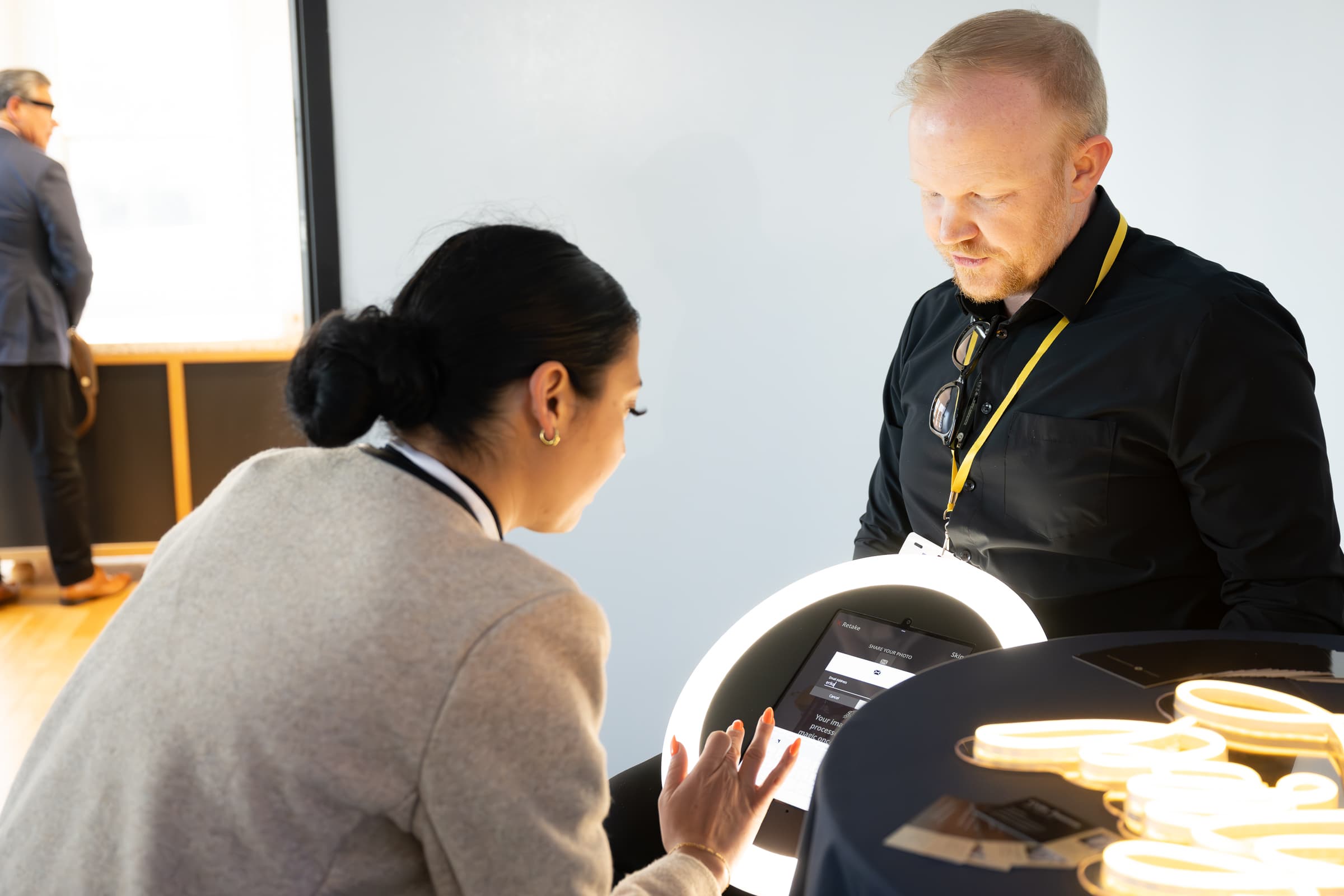 Two operators running a lit content-capture station at an event