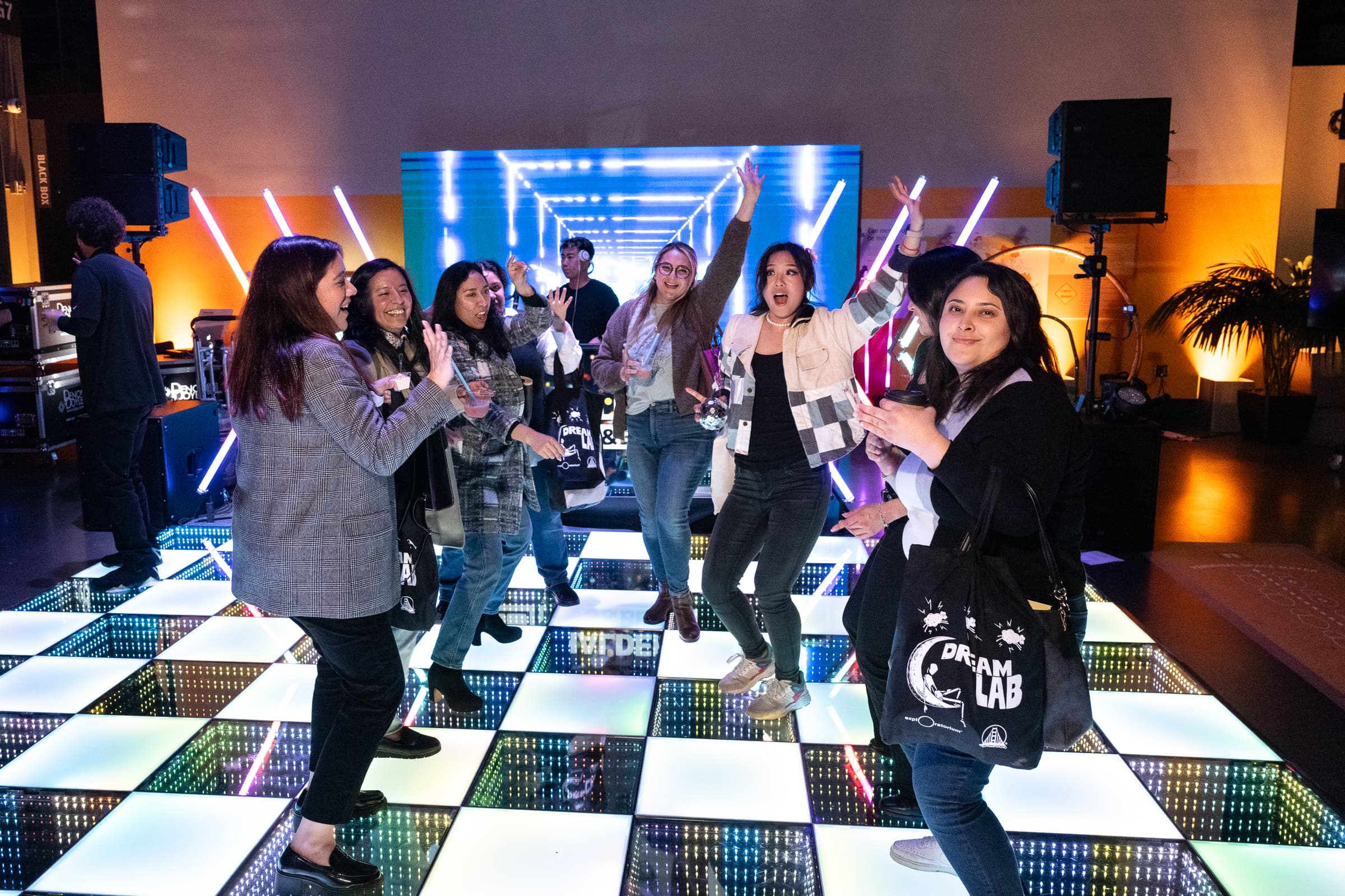 Guests dancing on an illuminated LED checkerboard floor