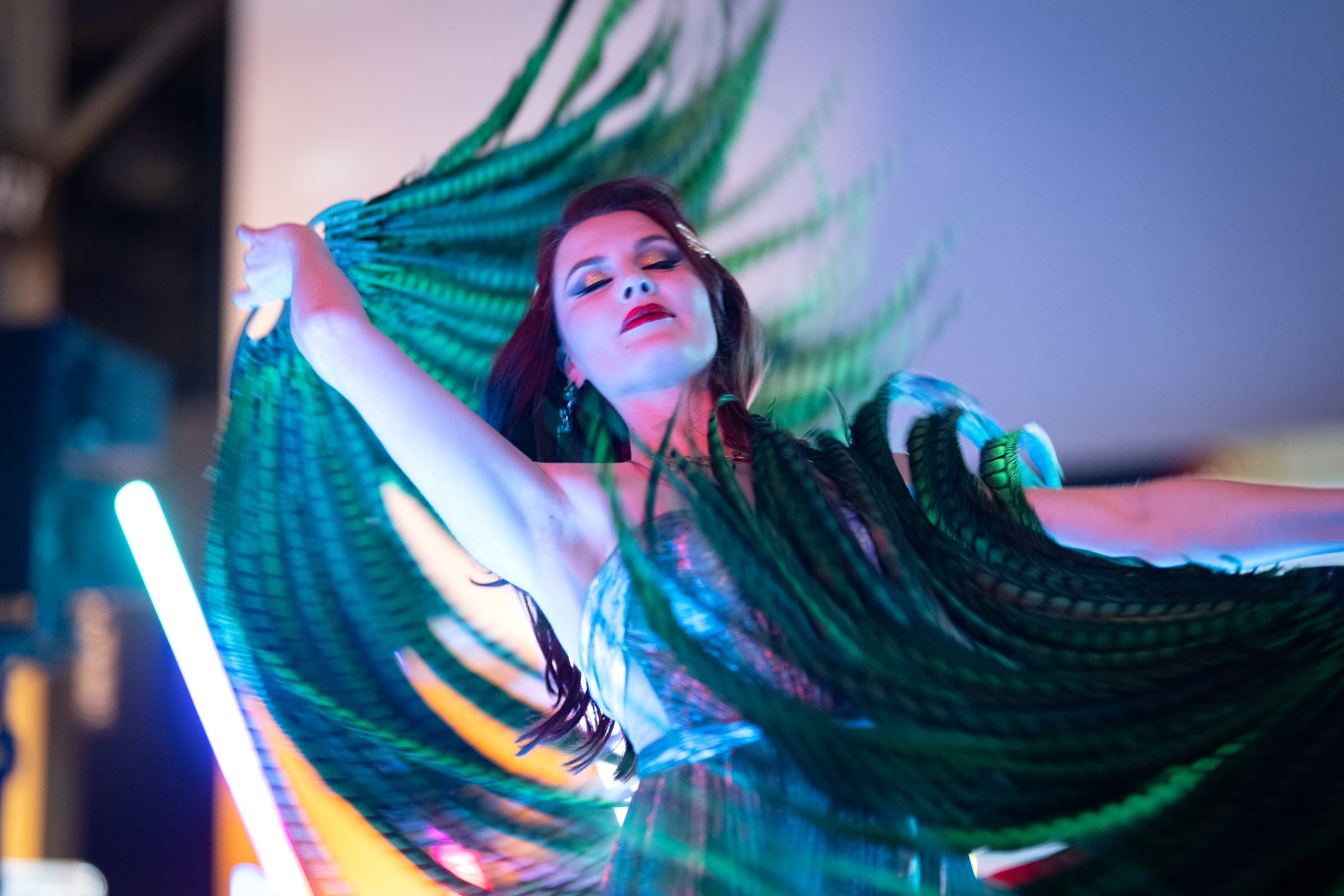 Dancer trailing green LED fans through a long exposure
