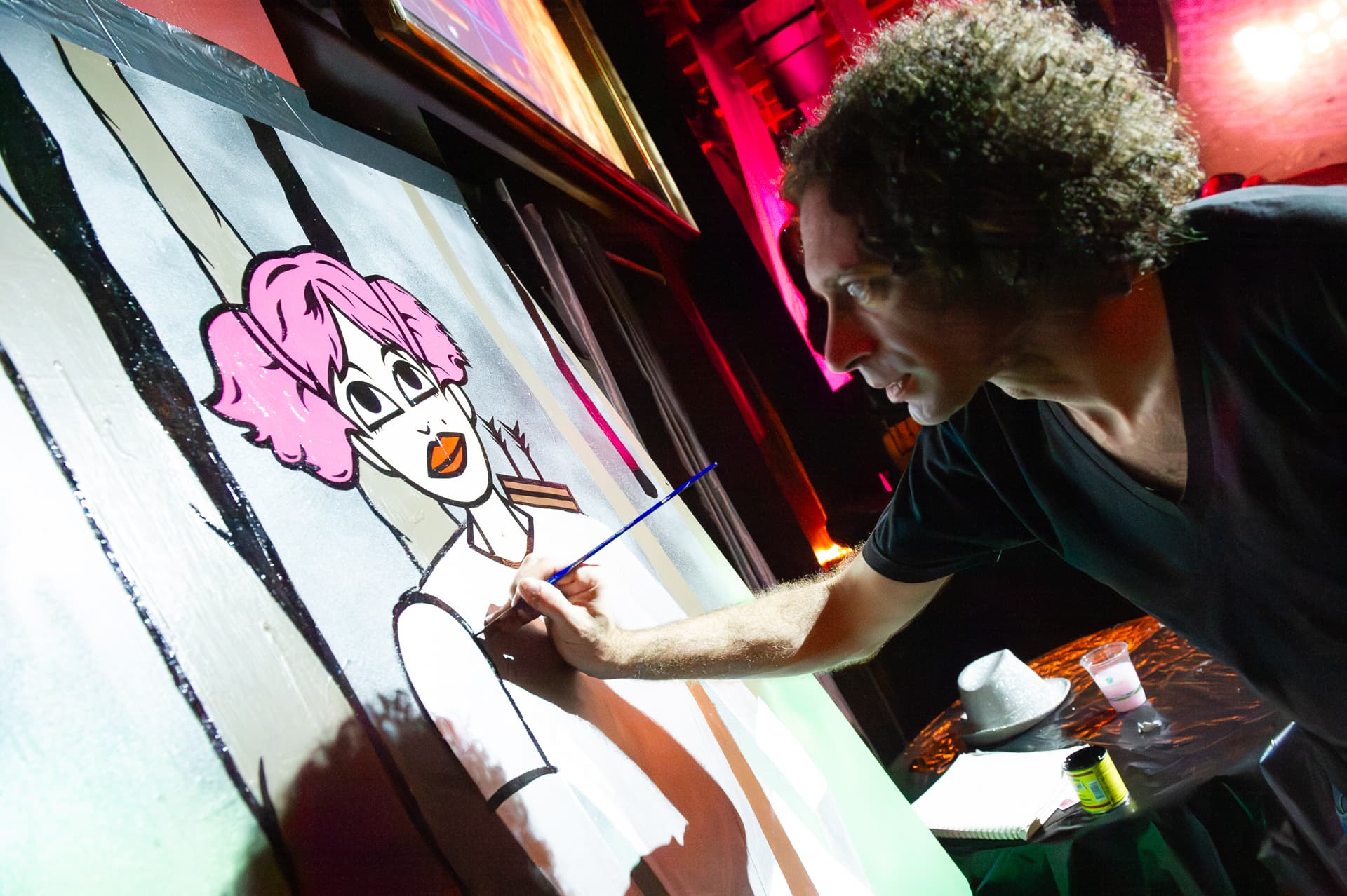 Digital caricature artist drawing a guest on a large illuminated tablet