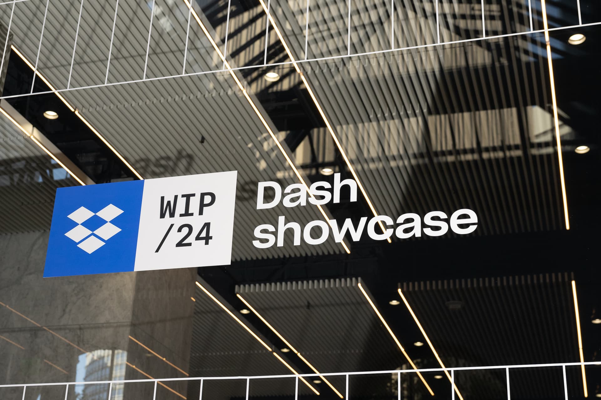 Dropbox Dash Showcase lettering on glass beneath a geometric ceiling at One Sansome