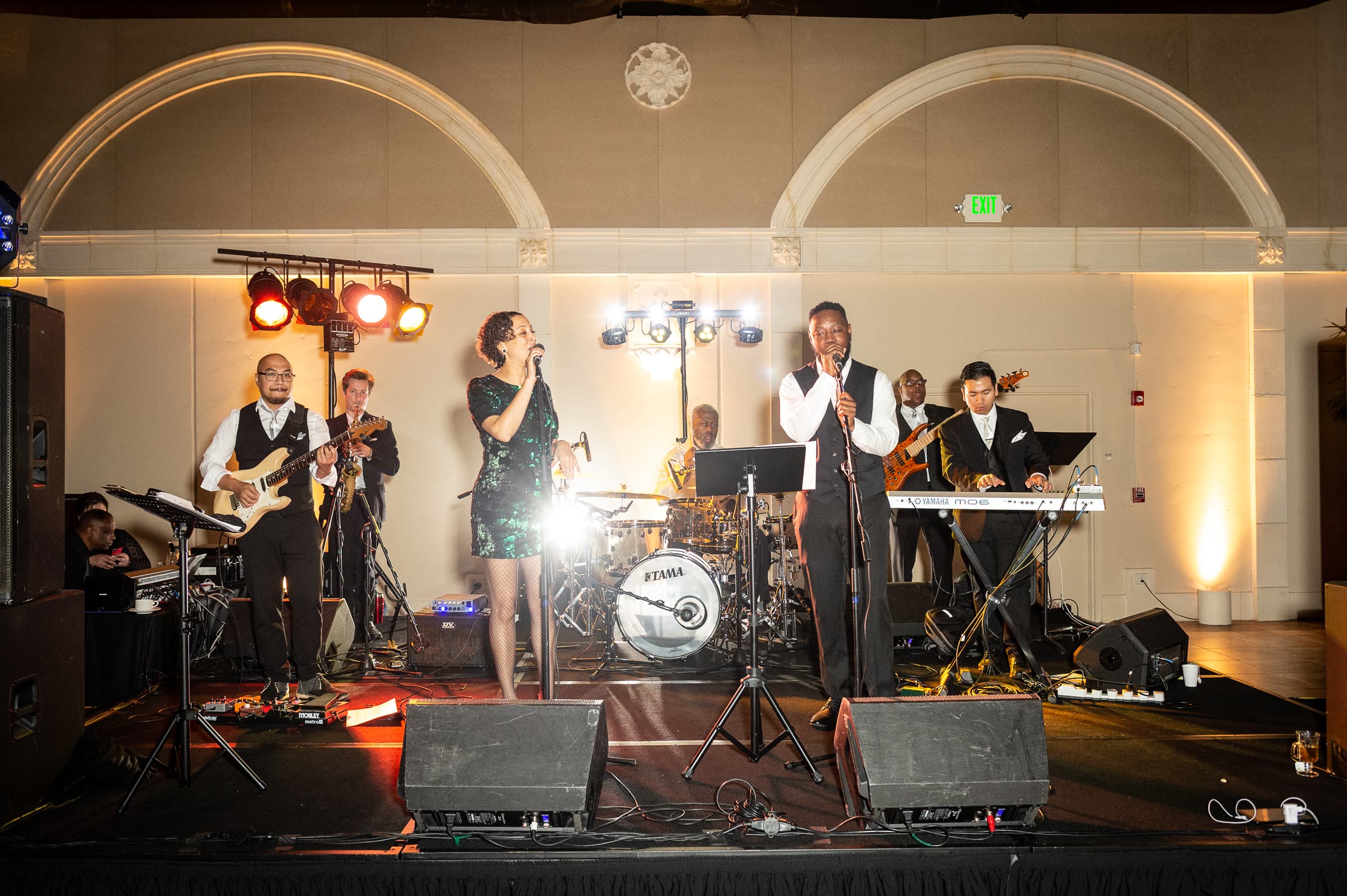 Live band performing on a small stage under warm uplighting