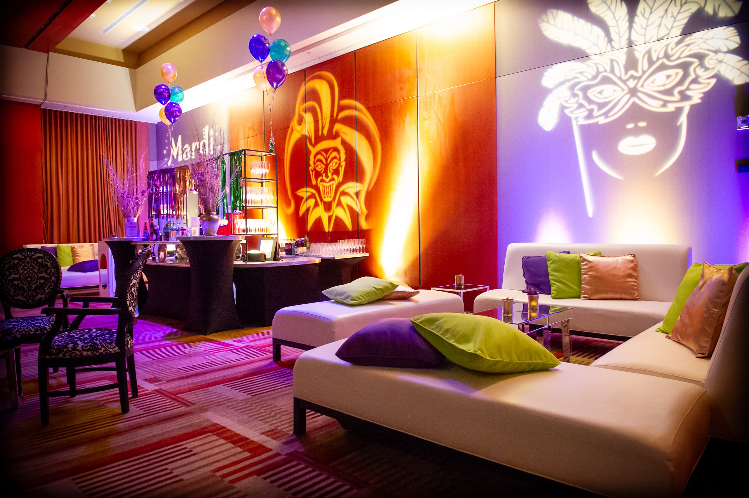 Lounge vignette with masquerade motifs projected across the walls