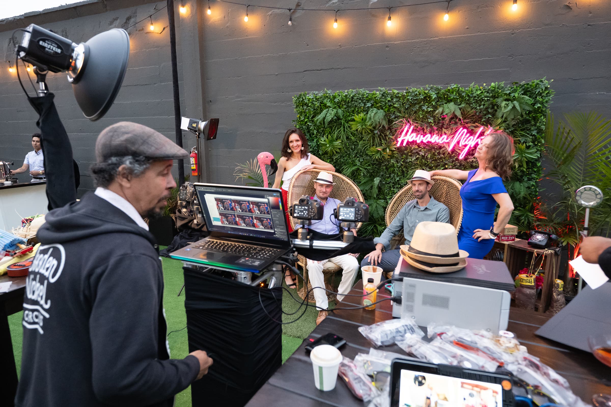 Operator running a tethered photo activation station beside a neon sign