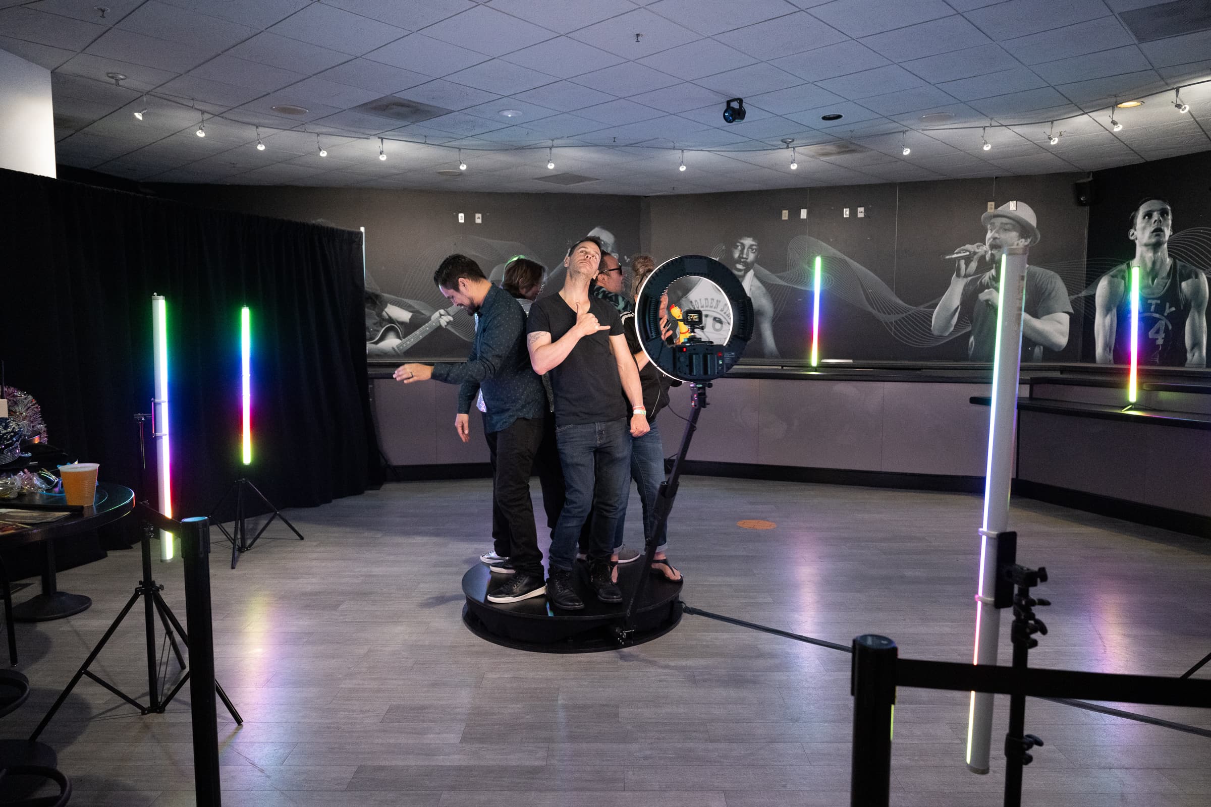 Guests riding a 360-degree video booth platform under LED tubes