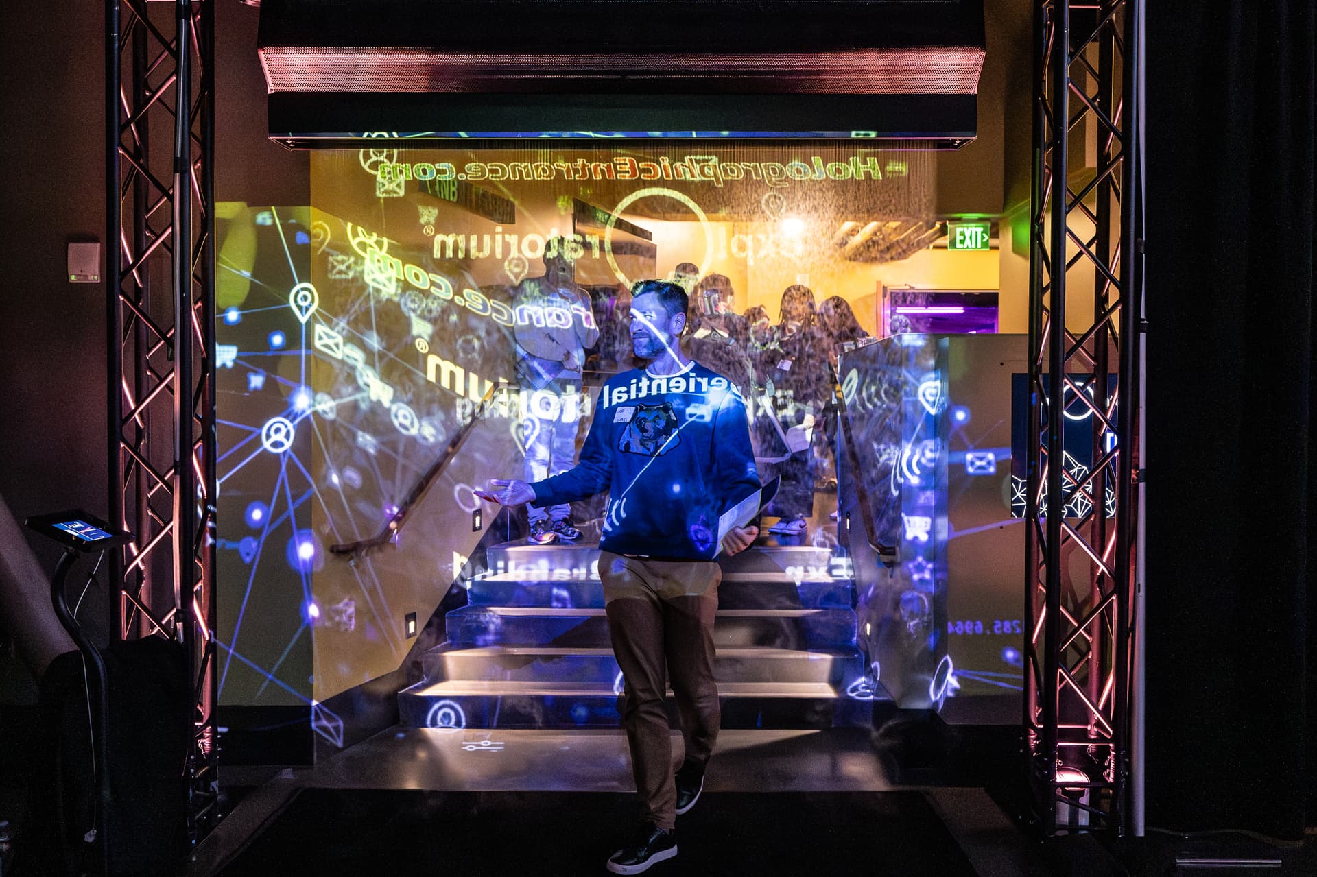 Person standing before technology display with blue projection mapping and digital motion graphics