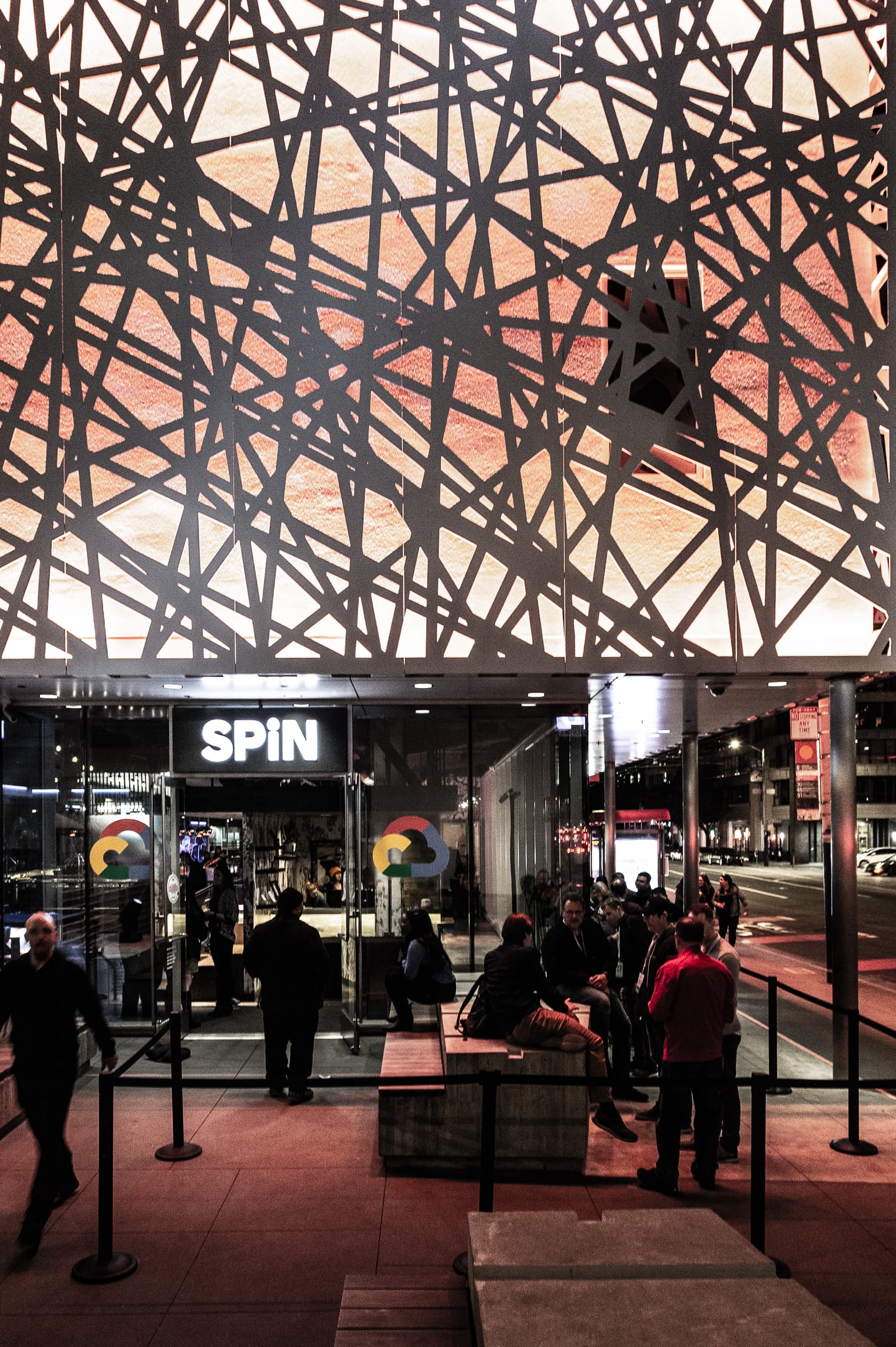 Guests outside the SPIN San Francisco entrance beneath a geometric overhead art installation