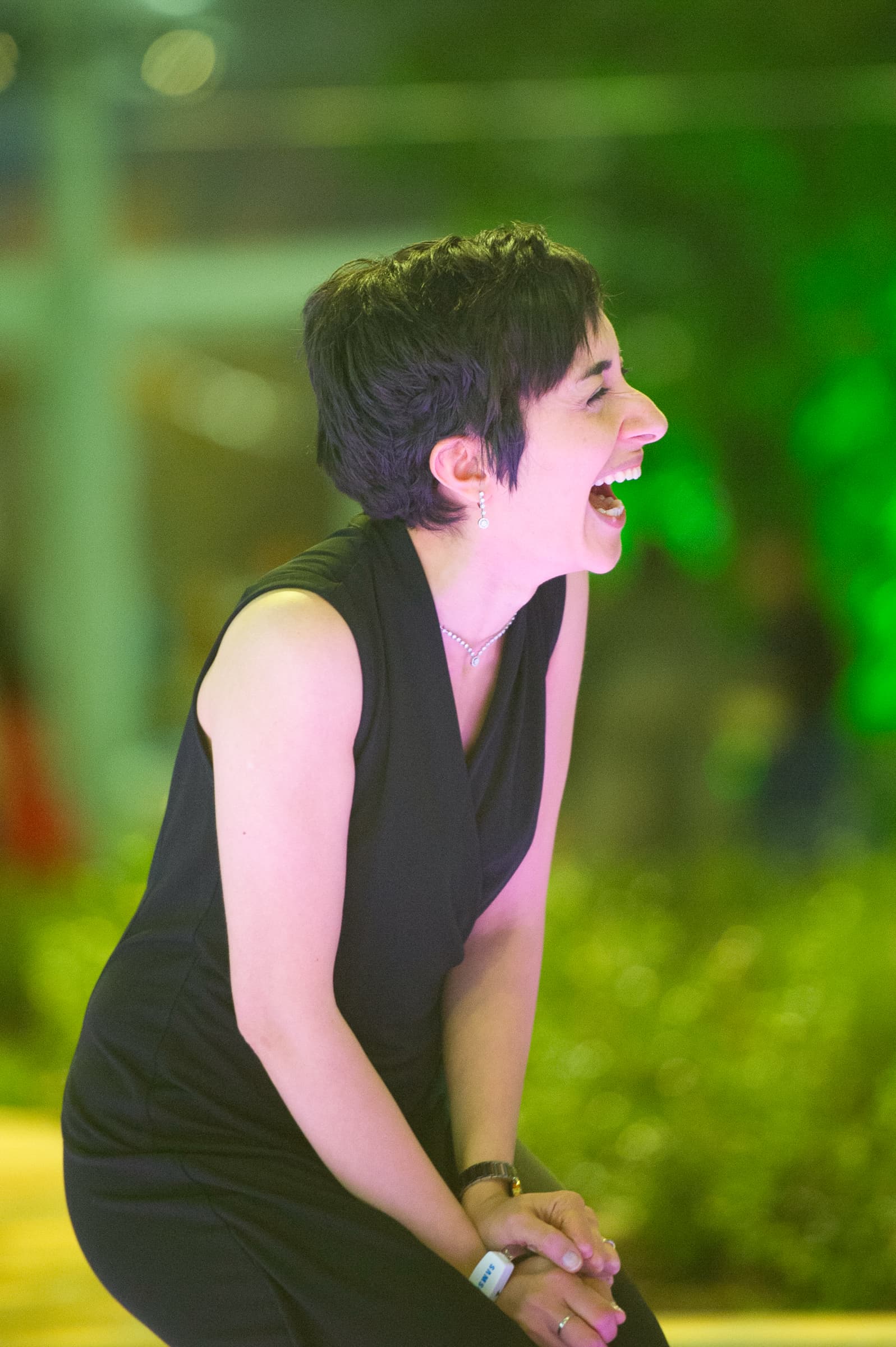 Vocalist performing under green stage light at an evening event