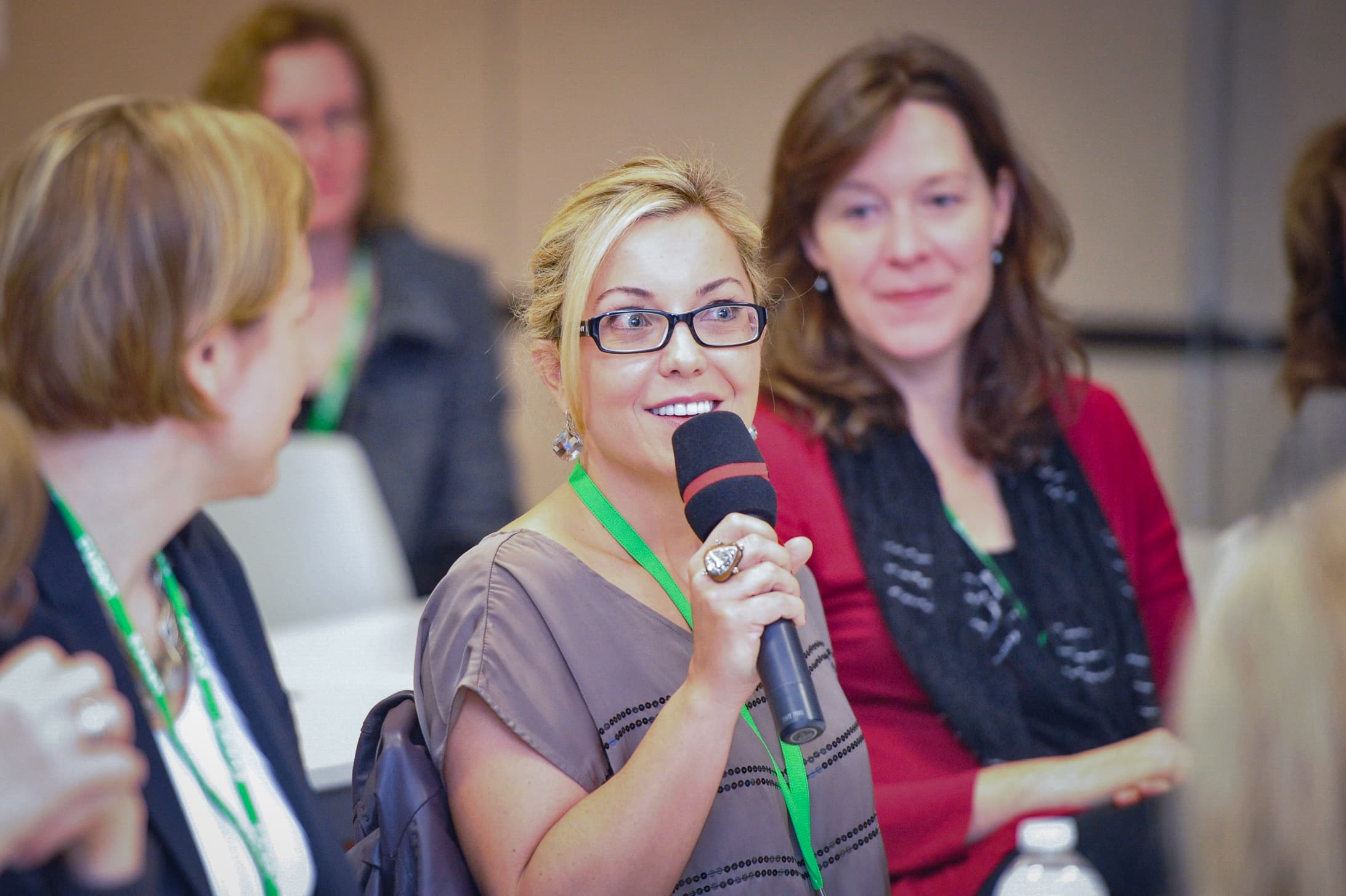 Attendee standing to ask a question on a handheld microphone during a session