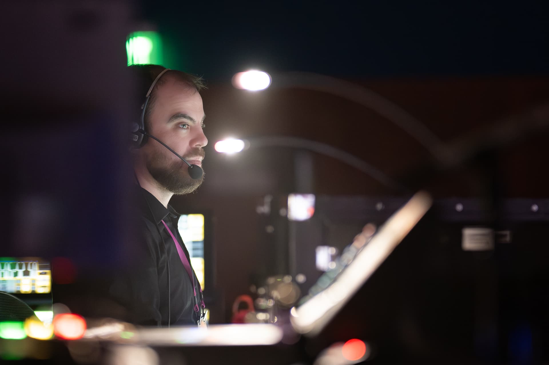 Event production technician wearing a headset behind control equipment at F5 AppWorld