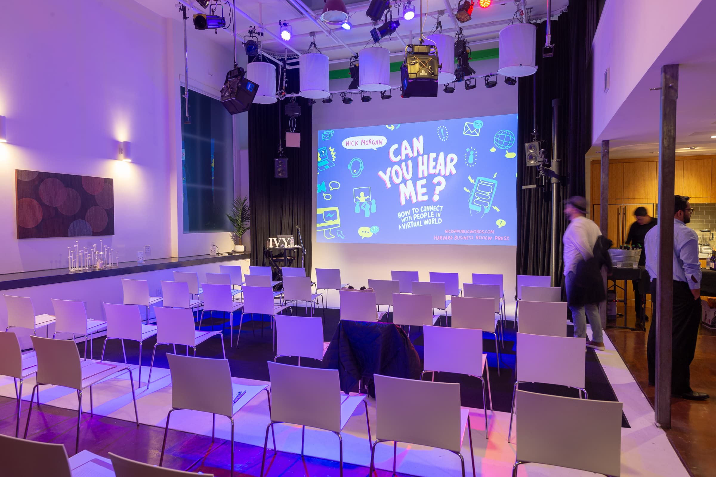 Loft venue set with rows of chairs facing a screen before a session