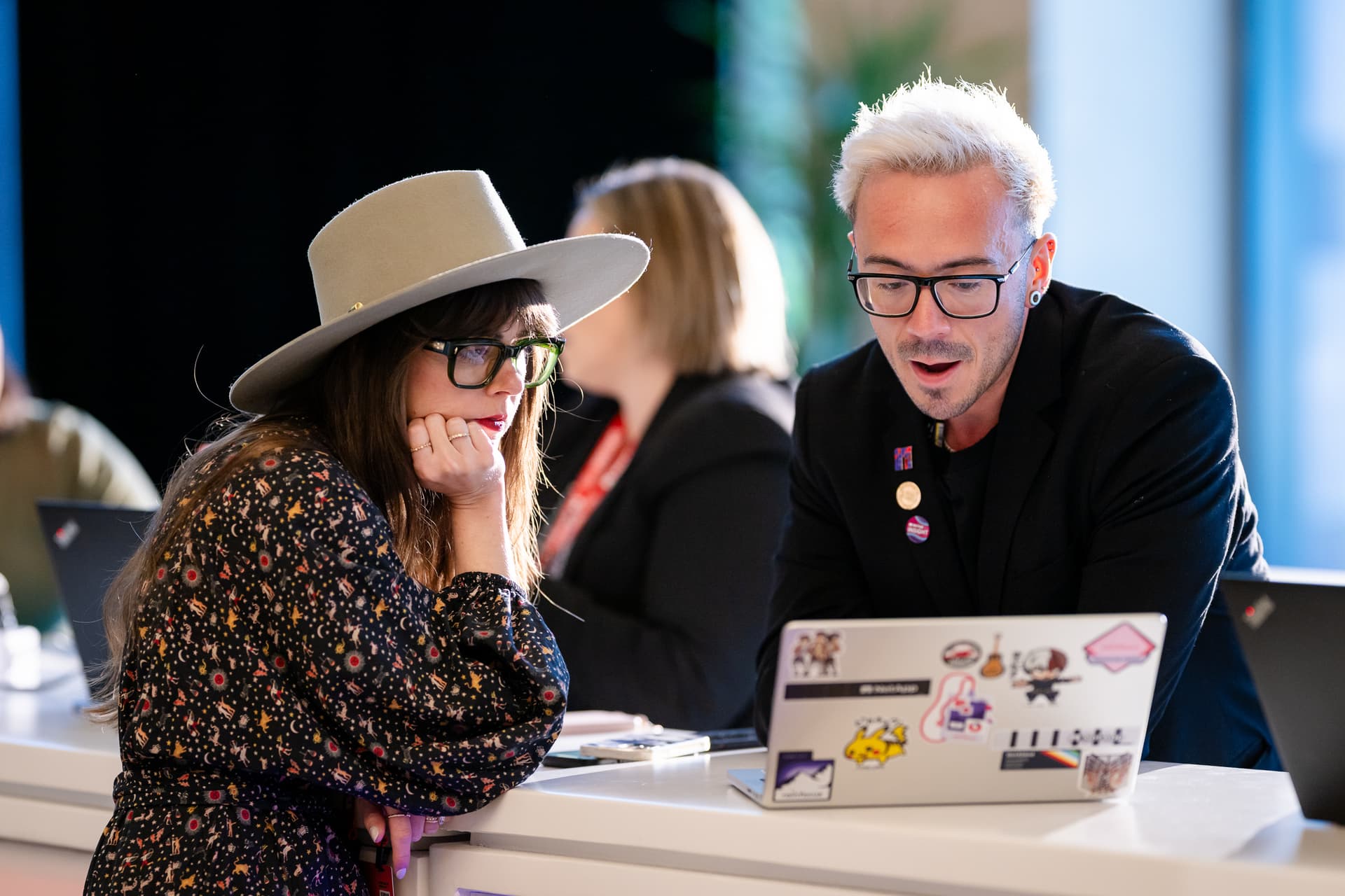 Staff member assisting attendee at branded exhibition booth setup