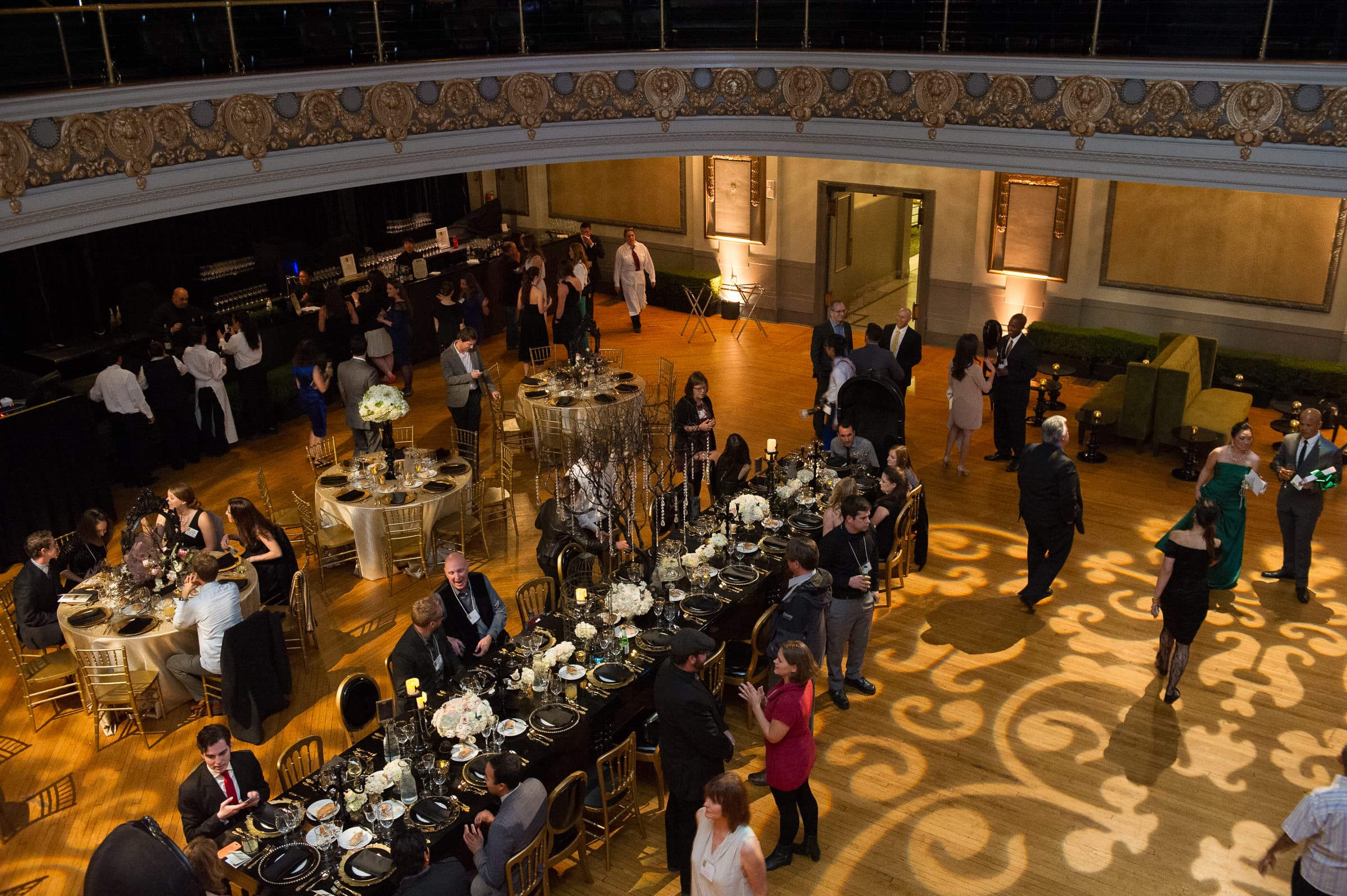 Overhead view of a long banquet hall as guests move between tables