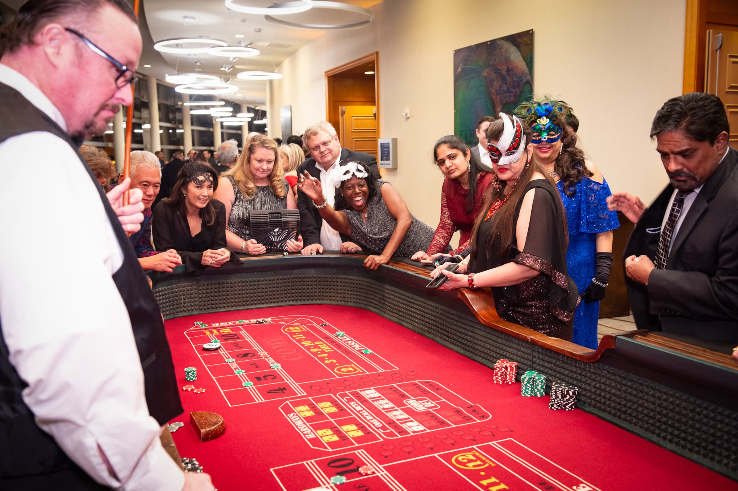 Guests gathered around a craps table at a casino-themed party