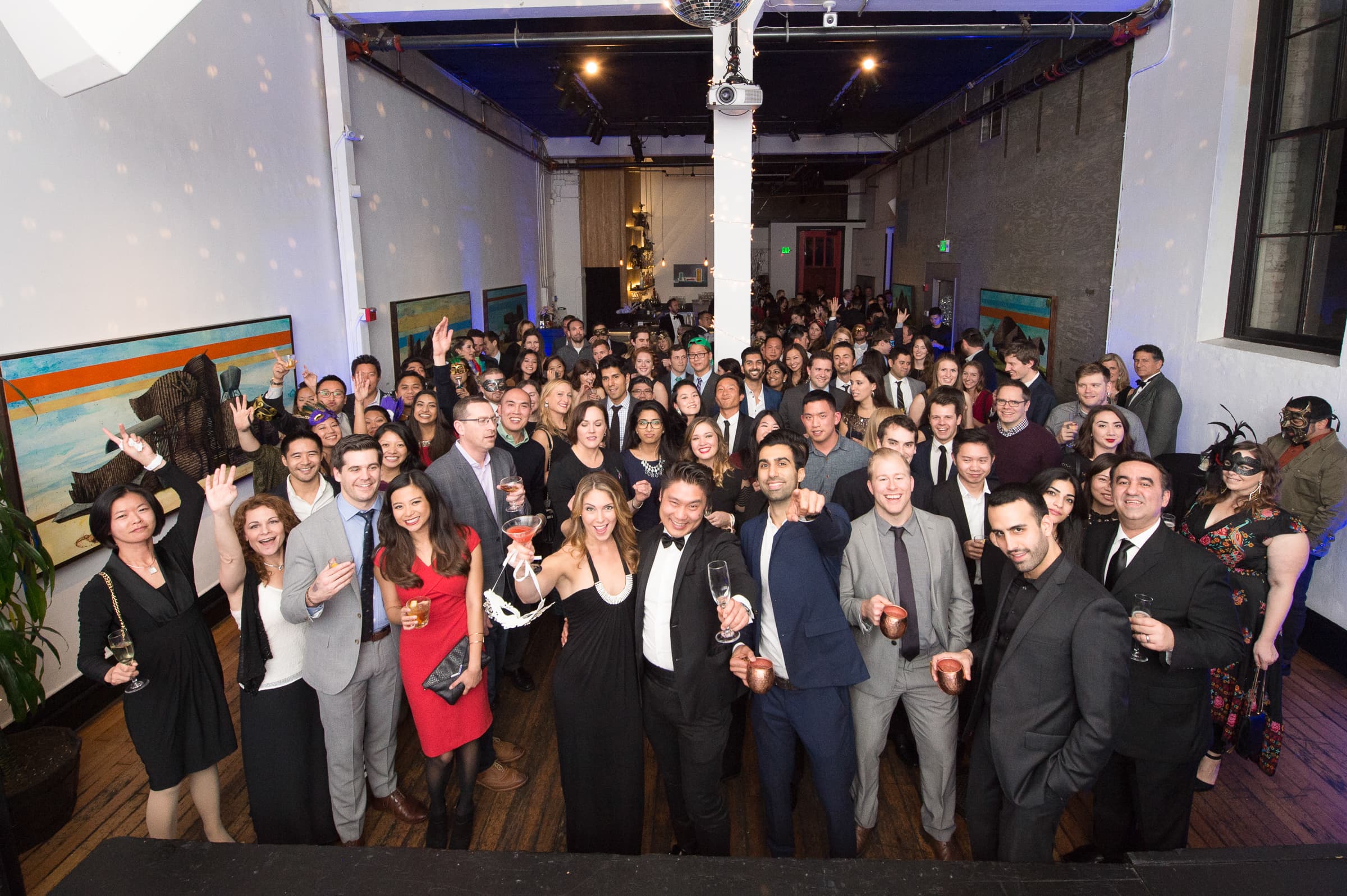 Company gathered together across a loft floor for a group photograph