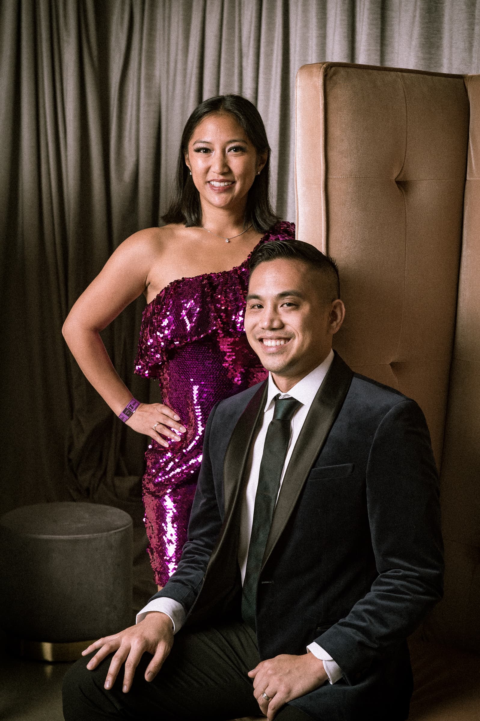 Elegantly dressed couple posing for formal portrait at gala event