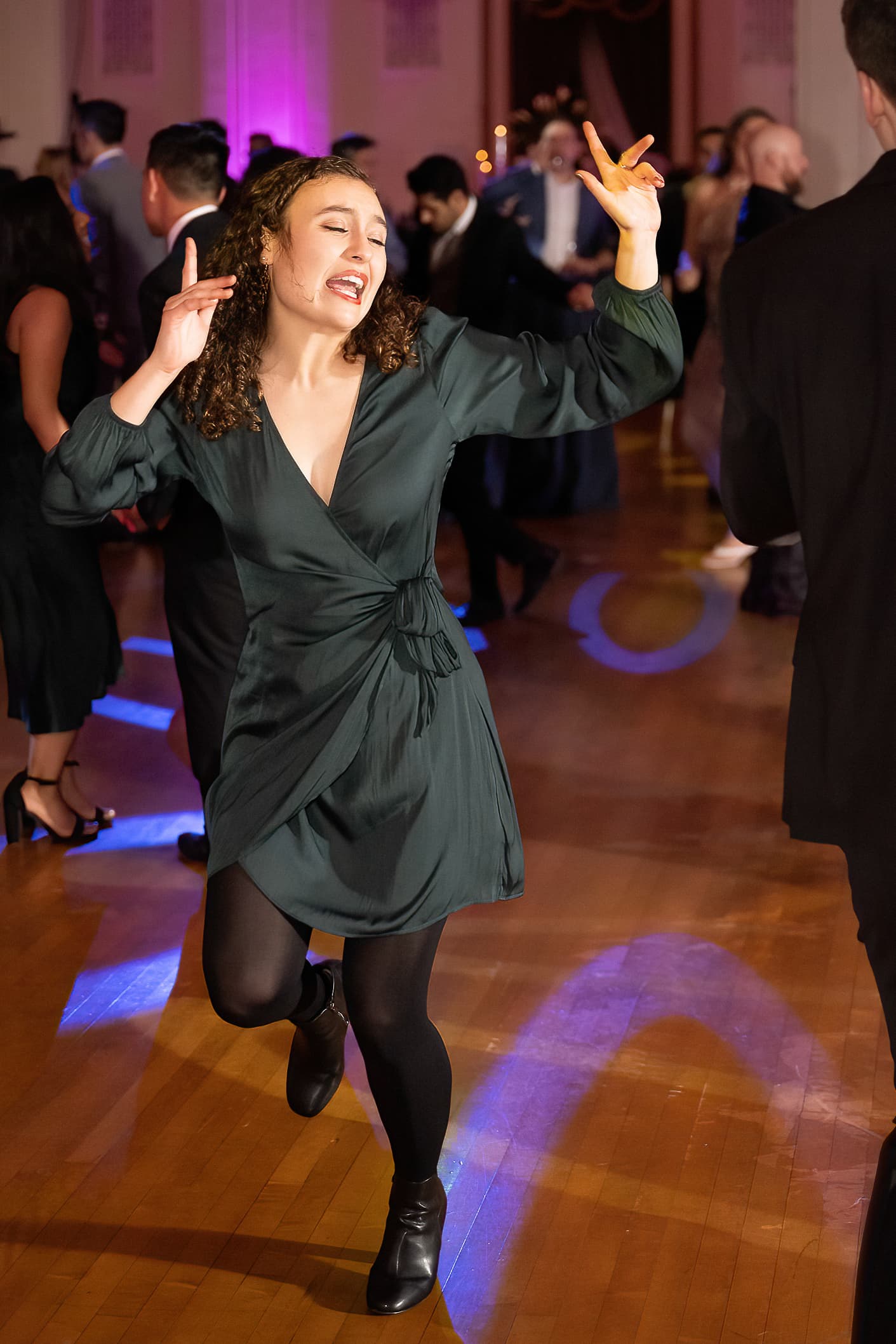 Woman dancing with expressive gesture on dance floor at formal gala event