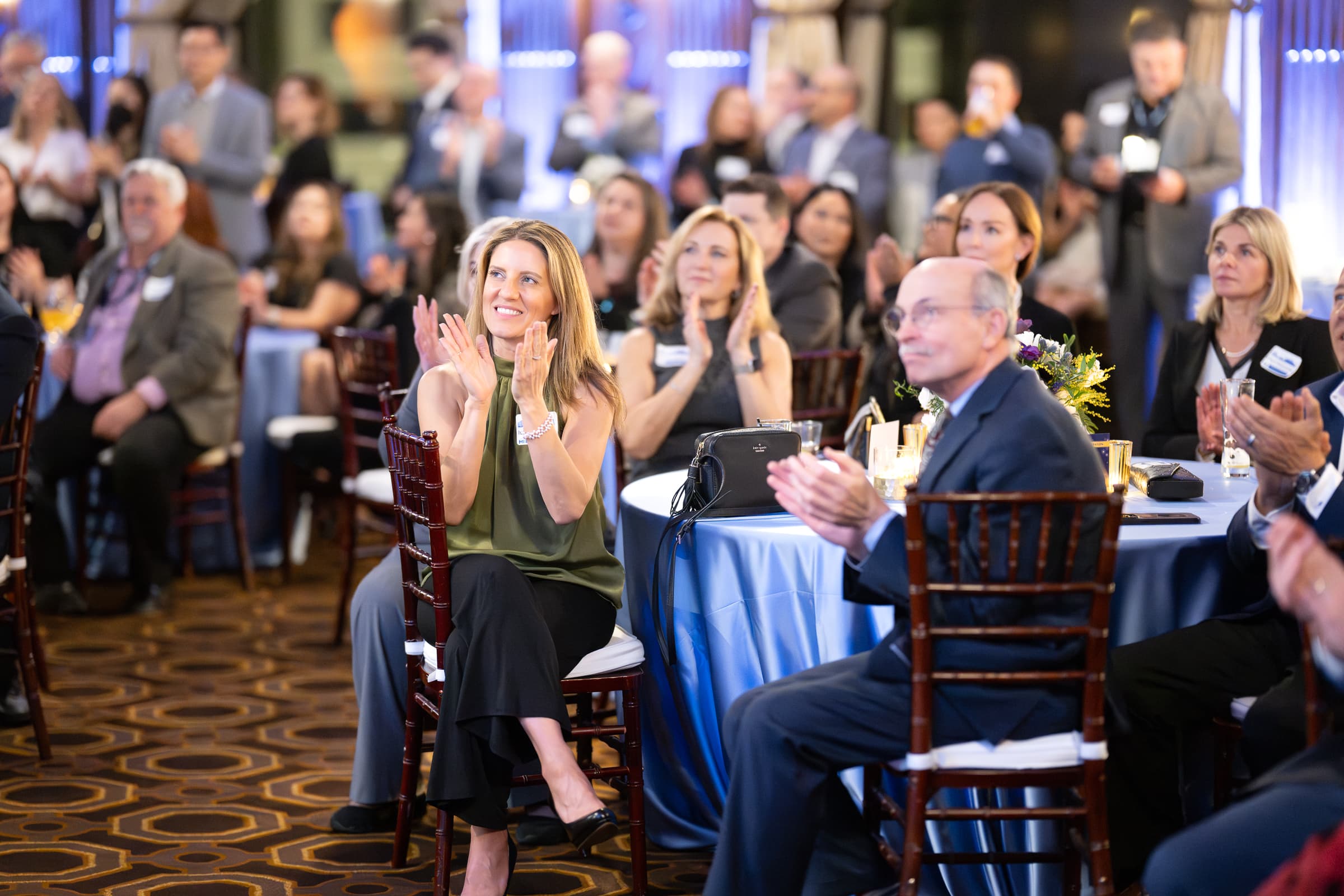 Guests applauding from banquet rounds during an awards programme