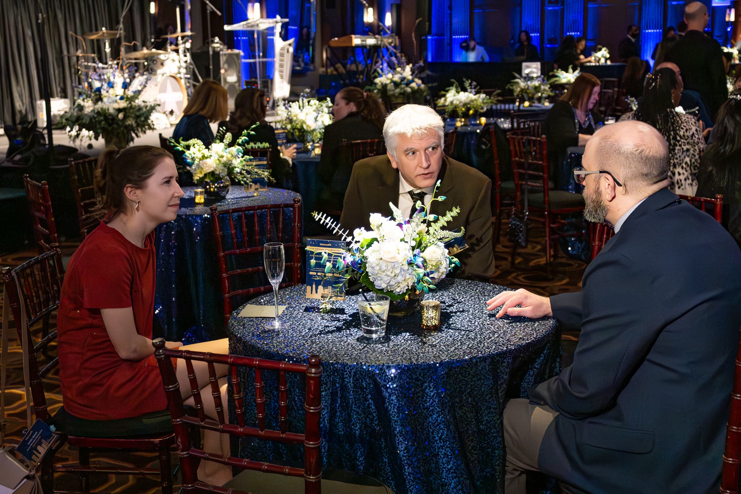 Guests in conversation around a table dressed with white florals